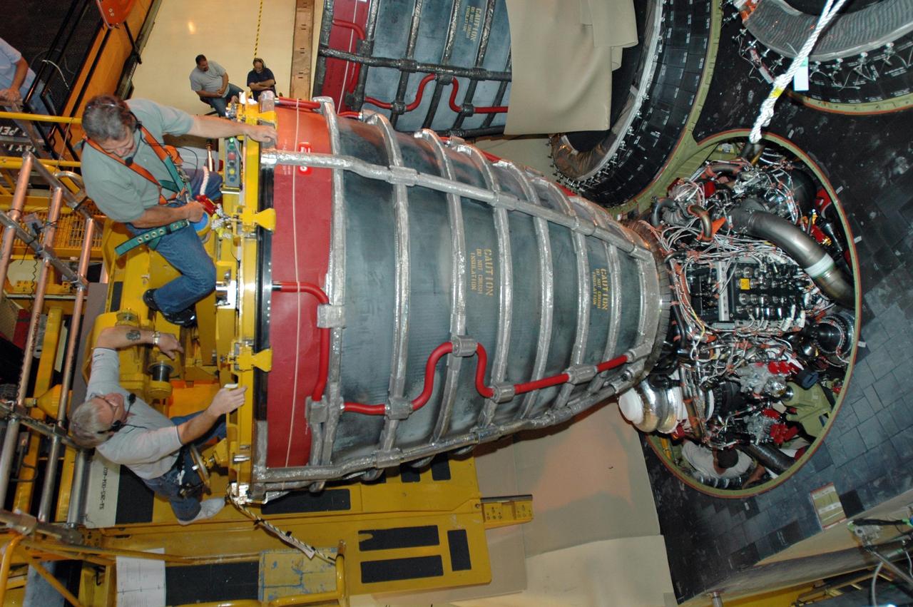 KENNEDY SPACE CENTER, FLA.  --   In this overhead view inside Orbiter Processing Facility 3 at Kennedy Space Center, technicians guide engine No. 3 toward the aft fuselage of Discovery for installation during processing for mission STS-120. Mission STS-120 will be the 23rd flight to the International Space Station. Space Shuttle Discovery will carry the U.S. Node 2. Launch is targeted for Oct. 20. NASA/Dimitri Gerondidakis