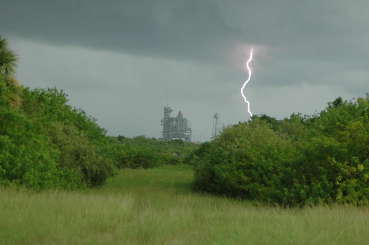 KENNEDY SPACE CENTER, FLA. -- A lightning strike is caught on camera during an afternoon thunderstorm at Kennedy Space Center, a common occurrence at this time of the year.  In the background, the rotating service structure encloses Space Shuttle Endeavour on Launch Pad 39A.  Endeavour is awaiting launch on mission STS-118.  The mission is the 20th flight for orbiter Endeavour and the 22nd flight to the International Space Station.  Launch is targeted for Aug. 7. Photo credit: NASA/Ken Thornsley