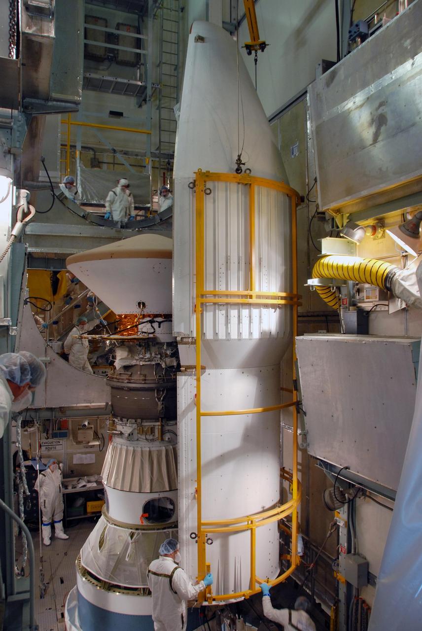 KENNEDY SPACE CENTER, FLA. -- On Launch Pad 17-A at Cape Canaveral Air Force Station, the first half of the fairing is moved toward the Phoenix Mars Lander for installation. Phoenix is targeted for launch on Aug. 3 aboard a Delta II rocket. The fairing is a molded structure that fits flush with the outside surface of the Delta II upper stage booster and forms an aerodynamically smooth nose cone, protecting the spacecraft during launch and ascent. Phoenix will land in icy soils near the north polar, permanent ice cap of Mars and explore the history of the water in these soils and any associated rocks, while monitoring polar climate. Landing on Mars is planned in May 2008 on arctic ground where a mission currently in orbit, Mars Odyssey, has detected high concentrations of ice just beneath the top layer of soil. NASA/George Shelton