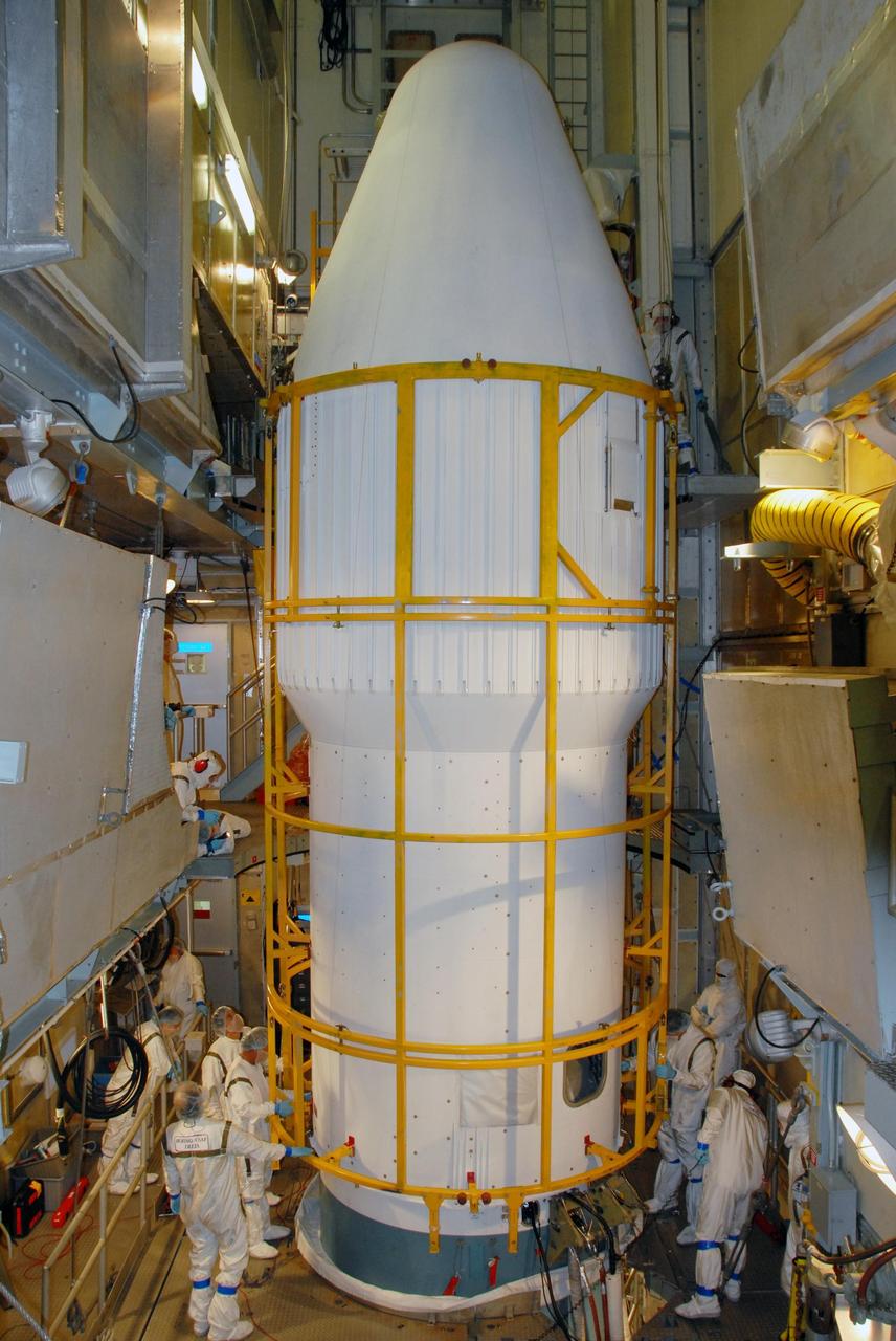 KENNEDY SPACE CENTER, FLA. -- On Launch Pad 17-A at Cape Canaveral Air Force Station, the two halves of the fairing come together for installation around the Phoenix Mars Lander. Phoenix is targeted for launch on Aug. 3 aboard a Delta II rocket. The fairing is a molded structure that fits flush with the outside surface of the Delta II upper stage booster and forms an aerodynamically smooth nose cone, protecting the spacecraft during launch and ascent. Phoenix will land in icy soils near the north polar, permanent ice cap of Mars and explore the history of the water in these soils and any associated rocks, while monitoring polar climate. Landing on Mars is planned in May 2008 on arctic ground where a mission currently in orbit, Mars Odyssey, has detected high concentrations of ice just beneath the top layer of soil. NASA/George Shelton