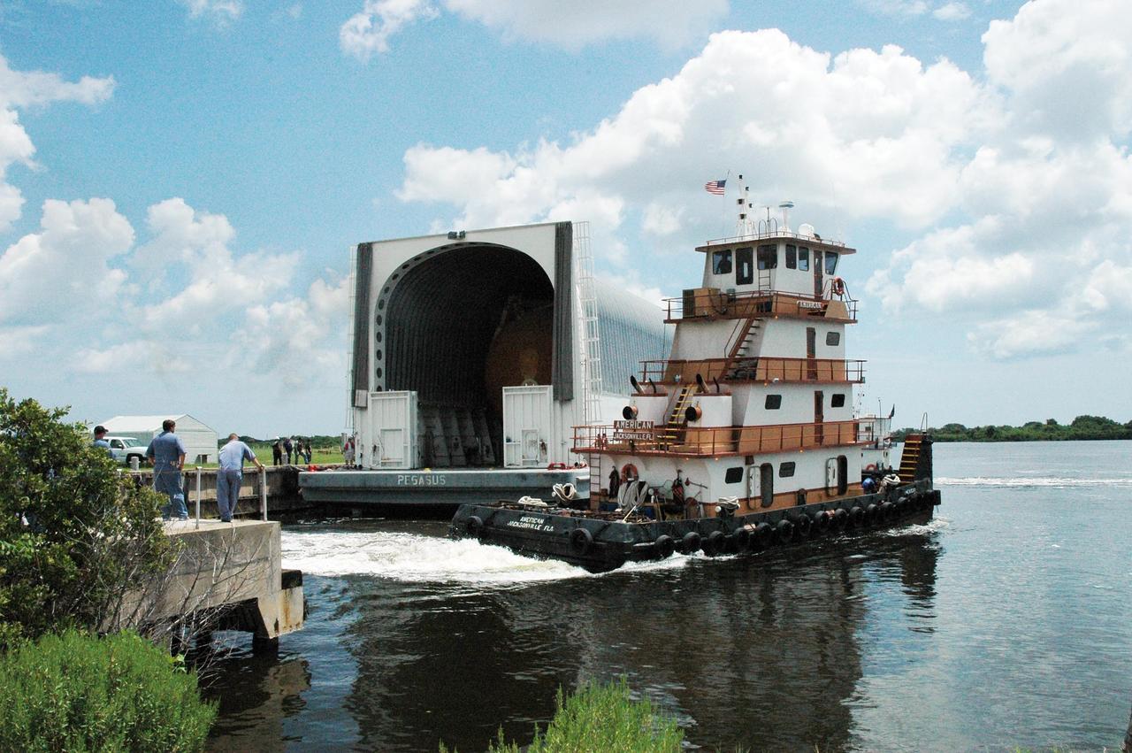 KENNEDY SPACE CENTER, FLA. --   In the Launch Complex 39 Area turn basin, the lead tugboat moves out of the way of the Pegasus barge so the barge can dock and offload its cargo.  The barge carries external tank No. 120, to be used for launching Space Shuttle Discovery on mission STS-120 in October. The barge has carried the tank from the Michoud Assembly Facility near New Orleans, making the journey around the Florida peninsula in tow by the JA Bisso II  tugboat, to Port Canaveral and Kennedy Space Center. After the tank is offloaded, it will be towed to the Vehicle Assembly Building for lifting into a checkout cell.   NASA/Amanda Diller
