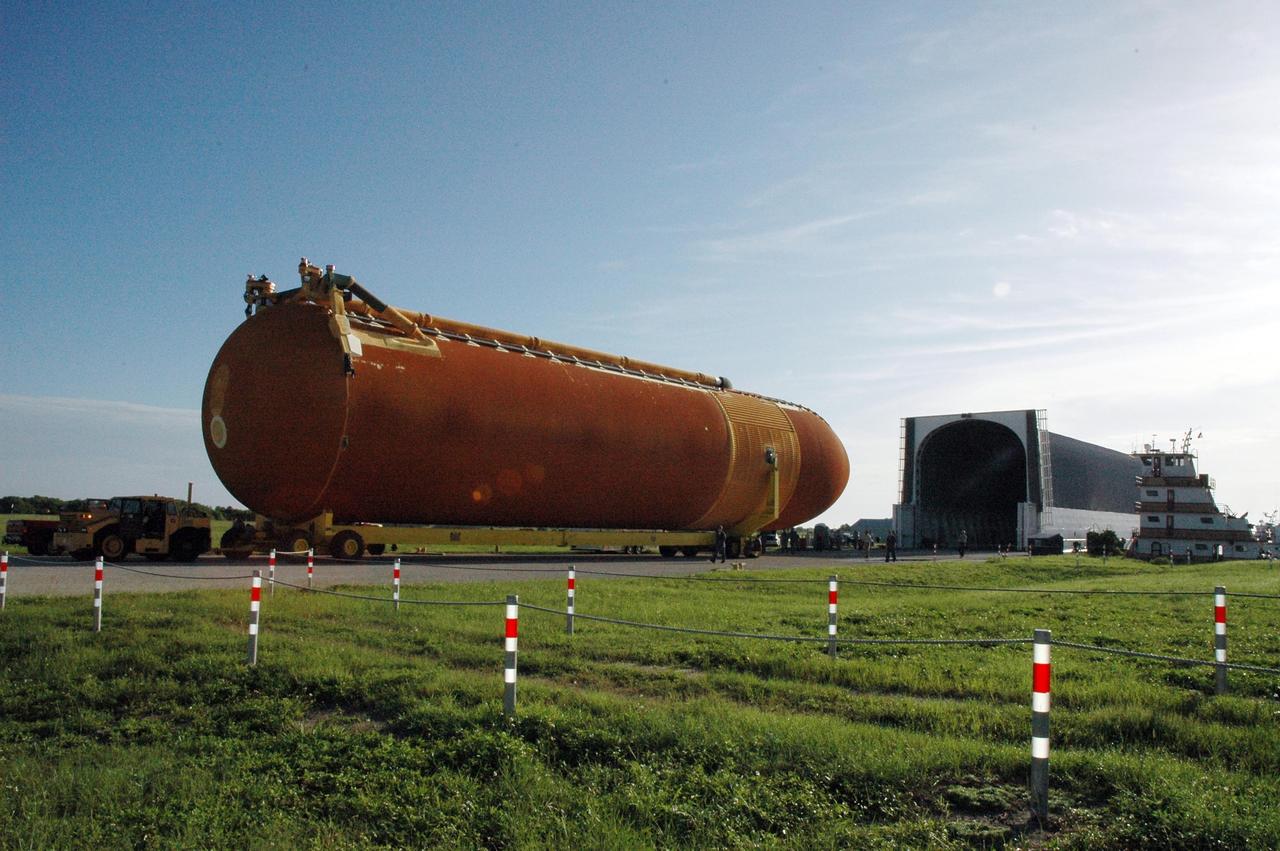 KENNEDY SPACE CENTER, FLA. --  A transporter moves external tank No. 120 away from the Pegasus barge, which is docked at the Launch Complex 39 Area turn basin.  The tank is being moved to the Vehicle Assembly Building and will be lifted into a checkout cell.  The barge carried the tank from the Michoud Assembly Facility near New Orleans, making the journey around the Florida peninsula in tow by the JA Bisso II  tugboat, to Port Canaveral and Kennedy Space Center. ET-120 will be used for launching Space Shuttle Discovery on mission STS-120 in October.  NASA/Amanda Diller