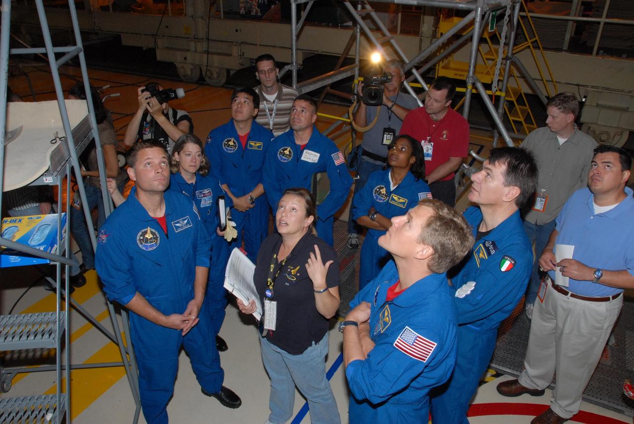 KENNEDY SPACE CENTER, FLA. - The STS-120 crew is at Kennedy for a crew equipment interface test, or CEIT.  Receiving instruction from Allison Bolinger, an EVA technician with NASA, under space shuttle Discovery in Orbiter Processing Facility bay 3 are, from left in blue flight suits, Mission Specialist Douglas H. Wheelock; Commander Pamela A. Melroy; Expedition 16 Flight Engineer Daniel M. Tani; Pilot George D. Zamka; and Mission Specialists Stephanie D. Wilson, Scott E. Parazynski and Paolo A. Nespoli, a European Space Agency astronaut from Italy.  Among the activities standard to a CEIT are harness training, inspection of the thermal protection system and camera operation for planned extravehicular activities, or EVAs. The STS-120 mission will deliver the Harmony module, christened after a school contest, which will provide attachment points for European and Japanese laboratory modules on the International Space Station. Known in technical circles as Node 2, it is similar to the six-sided Unity module that links the U.S. and Russian sections of the station. Built in Italy for the United States, Harmony will be the first new U.S. pressurized component to be added.  The STS-120 mission is targeted to launch on Oct. 20.  Photo credit: NASA/George Shelton
