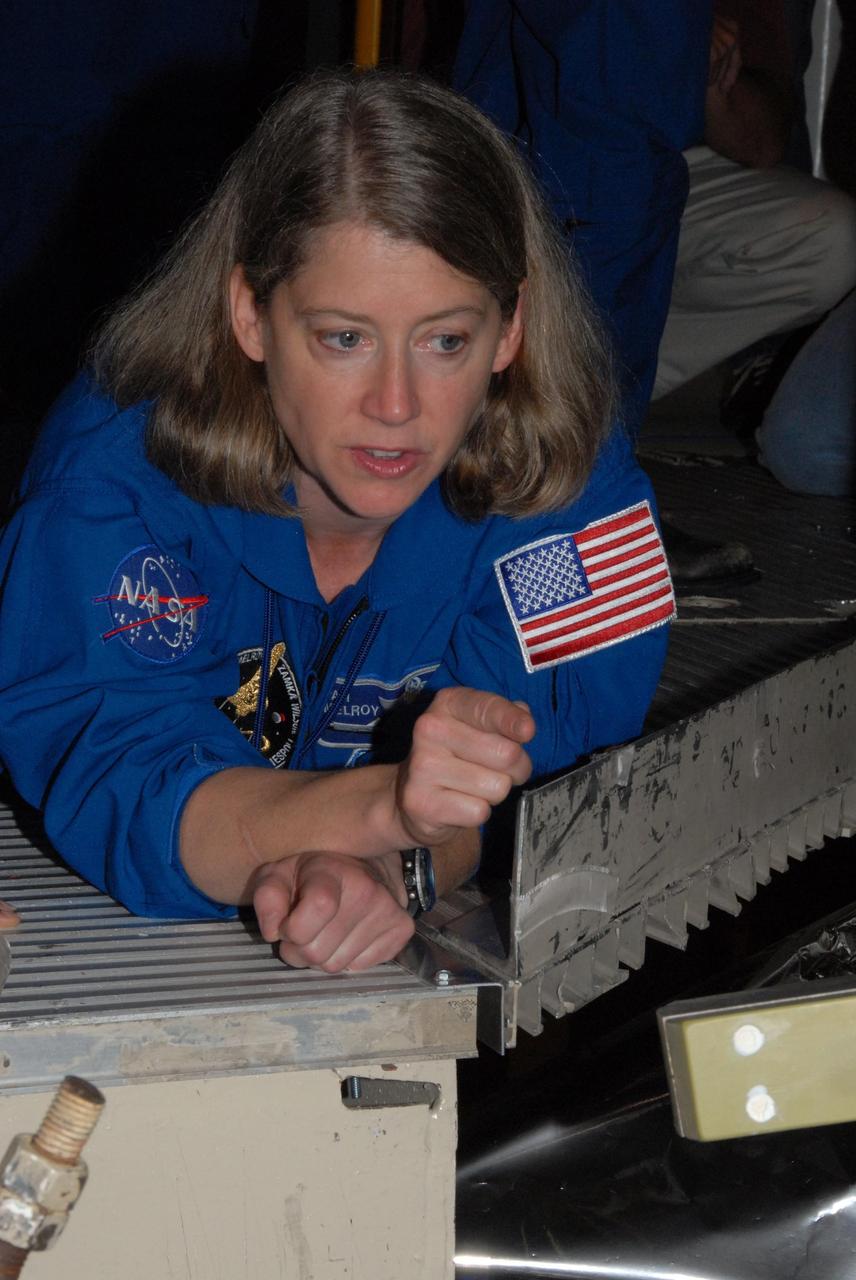 KENNEDY SPACE CENTER, FLA. - The STS-120 crew is at Kennedy for a crew equipment interface test, or CEIT.  Commander Pamela A. Melroy gives a close inspection to space shuttle Discovery in Orbiter Processing Facility bay 3.  Among the activities standard to a CEIT are harness training, inspection of the thermal protection system and camera operation for planned extravehicular activities, or EVAs. The STS-120 mission will deliver the Harmony module, christened after a school contest, which will provide attachment points for European and Japanese laboratory modules on the International Space Station. Known in technical circles as Node 2, it is similar to the six-sided Unity module that links the U.S. and Russian sections of the station. Built in Italy for the United States, Harmony will be the first new U.S. pressurized component to be added.  The STS-120 mission is targeted to launch on Oct. 20.  Photo credit: NASA/George Shelton