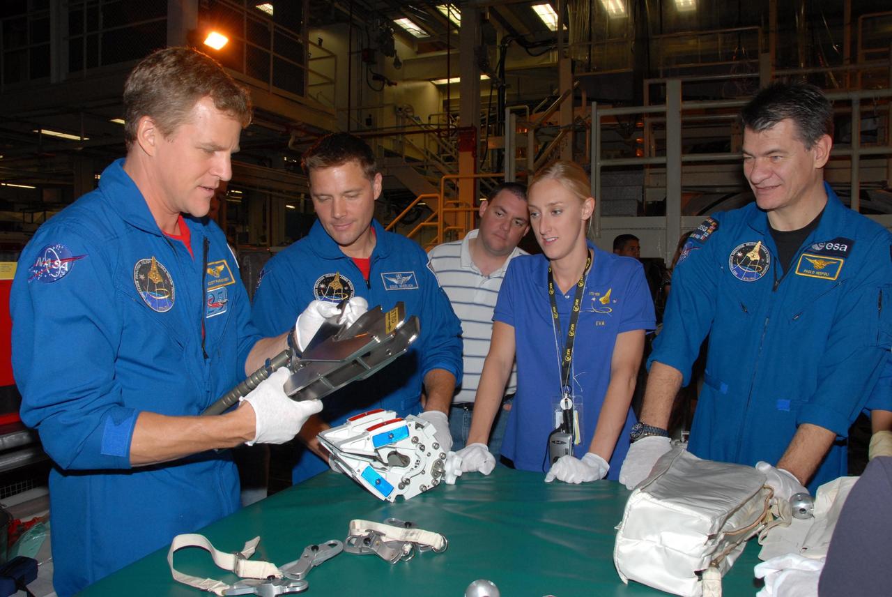 KENNEDY SPACE CENTER, FLA. - In Orbiter Processing Facility bay 3, STS-120 Mission Specialists Scott E. Parazynski, Douglas H. Wheelock and Paolo A. Nespoli inspect tools they will use during the mission. Nespoli is a European Space Agency astronaut from Italy. With them is Allison Bolinger, an EVA technician with NASA.  The STS-120 crew is at Kennedy for a crew equipment interface test, or CEIT, which includes harness training, inspection of the thermal protection system and camera operation for planned extravehicular activities, or EVAs. The STS-120 mission will deliver the Harmony module, christened after a school contest, which will provide attachment points for European and Japanese laboratory modules on the International Space Station. Known in technical circles as Node 2, it is similar to the six-sided Unity module that links the U.S. and Russian sections of the station. Built in Italy for the United States, Harmony will be the first new U.S. pressurized component to be added.  The STS-120 mission is targeted to launch on Oct. 20.  Photo credit: NASA/George Shelton