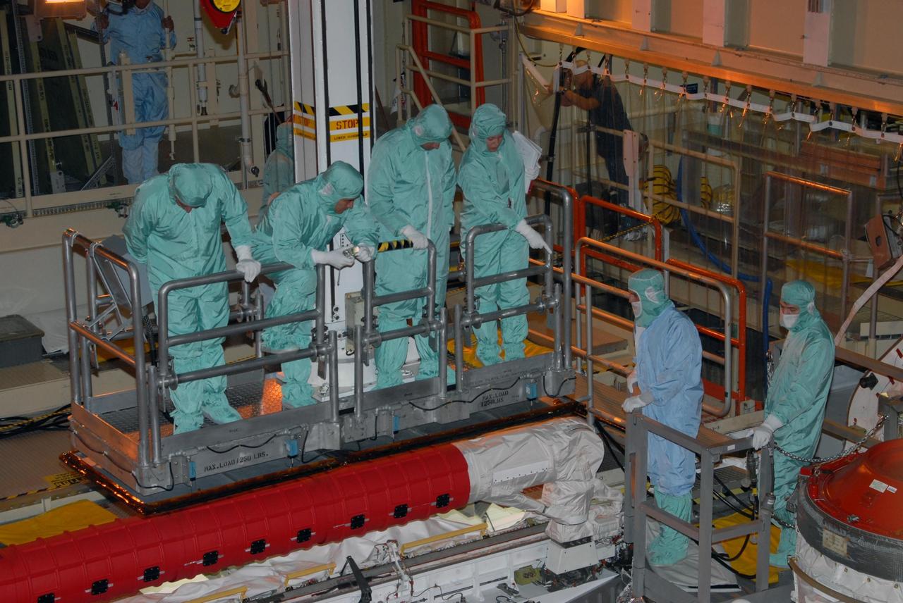 KENNEDY SPACE CENTER, FLA. - In Orbiter Processing Facility bay 3, STS-120 crew members get a close look at hardware in Discovery's payload bay.  The crew includes Commander Pamela A. Melroy, Pilot George D. Zamka and Mission Specialists Scott E. Parazynski, Douglas H. Wheelock, Stephanie D. Wilson and Paolo A. Nespoli, who is a European Space Agency astronaut from Italy. The STS-120 crew is at Kennedy for a crew equipment interface test, or CEIT, which includes harness training, inspection of the thermal protection system and camera operation for planned extravehicular activities, or EVAs. The STS-120 mission will deliver the Harmony module, christened after a school contest, which will provide attachment points for European and Japanese laboratory modules on the International Space Station. Known in technical circles as Node 2, it is similar to the six-sided Unity module that links the U.S. and Russian sections of the station. Built in Italy for the United States, Harmony will be the first new U.S. pressurized component to be added.  The STS-120 mission is targeted to launch on Oct. 20. Photo credit: NASA/George Shelton