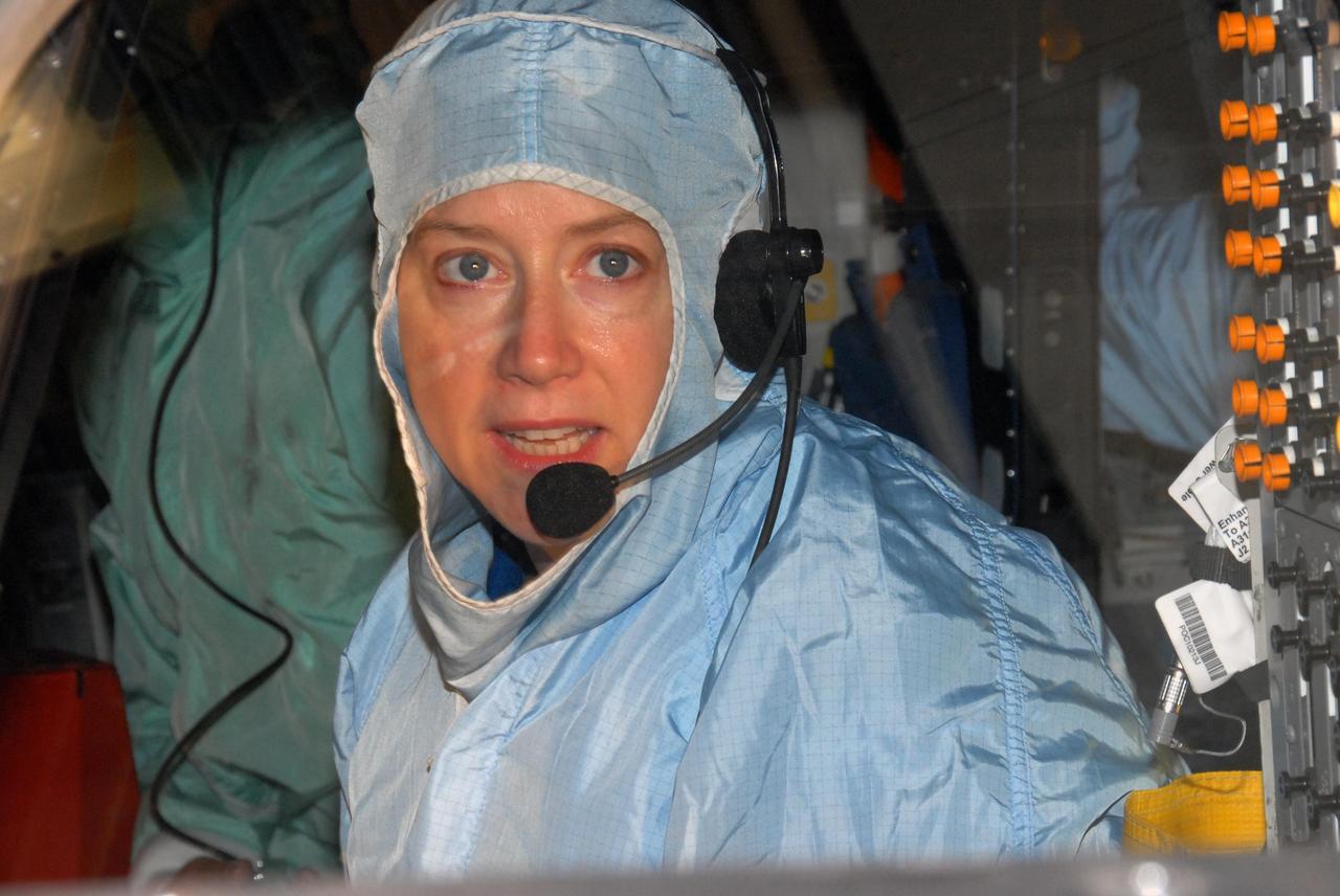 KENNEDY SPACE CENTER, FLA. - In the Orbiter Processing Facility bay 3, STS-120 Commander Pamela A. Melroy sits in the orbiter Discovery to inspect the cockpit windows.  The STS-120 crew is at Kennedy for a crew equipment interface test, or CEIT, which includes harness training, inspection of the thermal protection system and camera operation for planned extravehicular activities, or EVAs. The STS-120 mission will deliver the Harmony module, christened after a school contest, which will provide attachment points for European and Japanese laboratory modules on the International Space Station. Known in technical circles as Node 2, it is similar to the six-sided Unity module that links the U.S. and Russian sections of the station. Built in Italy for the United States, Harmony will be the first new U.S. pressurized component to be added.  The STS-120 mission is targeted to launch on Oct. 20.  Photo credit: NASA/George Shelton