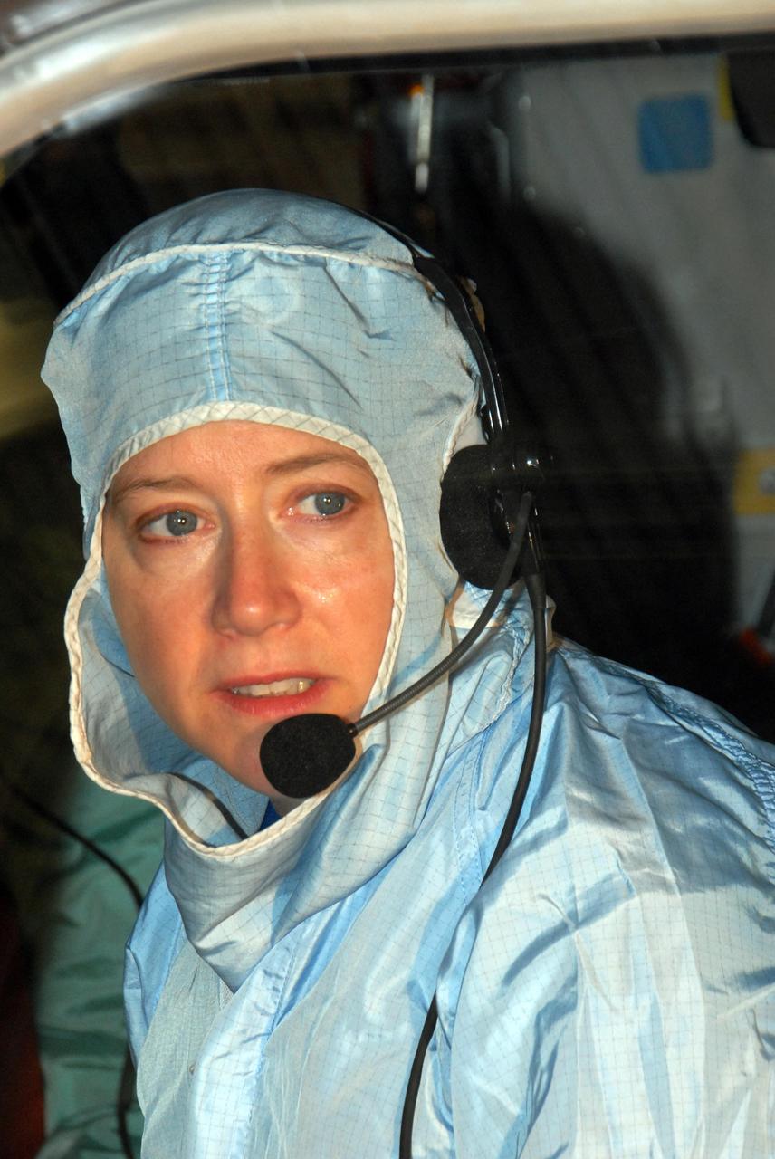 KENNEDY SPACE CENTER, FLA. - In the Orbiter Processing Facility bay 3,STS-120 Commander Pamela A. Melroy sits in the orbiter Discovery to inspect the cockpit windows. The STS-120 crew is at Kennedy for a crew equipment interface test, or CEIT, which includes harness training, inspection of the thermal protection system and camera operation for planned extravehicular activities, or EVAs. The STS-120 mission will deliver the Harmony module, christened after a school contest, which will provide attachment points for European and Japanese laboratory modules on the International Space Station. Known in technical circles as Node 2, it is similar to the six-sided Unity module that links the U.S. and Russian sections of the station. Built in Italy for the United States, Harmony will be the first new U.S. pressurized component to be added.  The STS-120 mission is targeted to launch on Oct. 20.  Photo credit: NASA/George Shelton