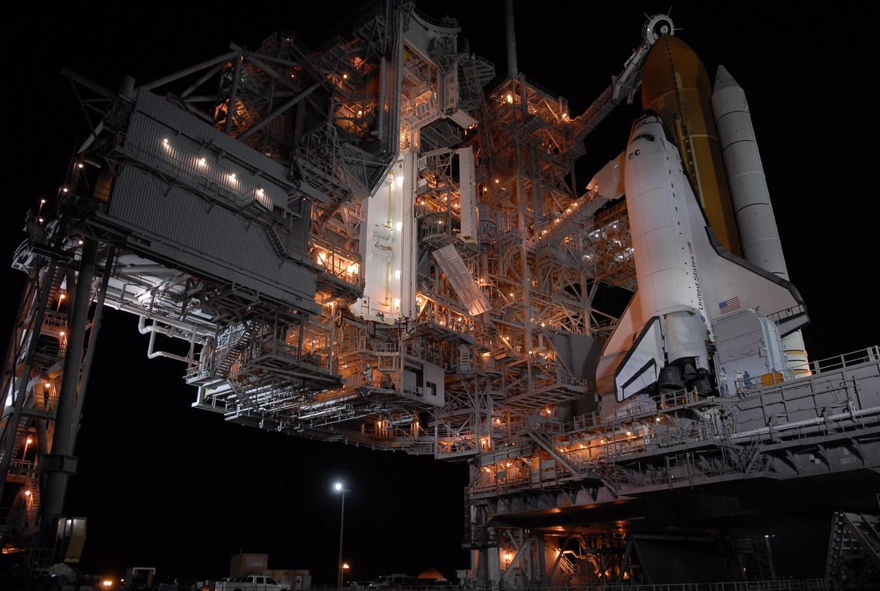KENNEDY SPACE CENTER, FLA. - Space Shuttle Endeavour is revealed on Launch Pad 39A after rollback of the rotating service structure, or RSS, at left of the pad.  Rollback started at 9 p.m. EDT Aug. 7 and was complete at 10:40 p.m.  Beneath the shuttle is the mobile launcher platform, which spans the flame trench below. The flame deflector system includes an inverted, V-shaped steel structure that receives and deflects the flames from the orbiter main engines on one side; the opposite side deflects the flames from the solid rocket boosters. The RSS provides protected access to the orbiter for changeout and servicing of payloads at the pad. Rollback of the pad's RSS is one of the milestones in preparation for the launch of mission STS-118 at 6:36 p.m. EDT on Aug. 8. Space Shuttle Endeavour's STS-118 mission is the 22nd shuttle flight to the International Space Station. It will continue space station construction by delivering a third starboard truss segment, S5, and other payloads such as the SPACEHAB module and the external stowage platform 3. Photo credit:  NASA/Kim Shiflett