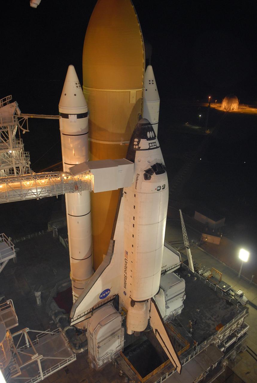 KENNEDY SPACE CENTER, FLA. - After rollback of the rotating service structure, or RSS, on Launch Pad 39A, Space Shuttle Endeavour stands bathed in spotlights. Rollback started at 9 p.m. EDT Aug. 7 and was complete at 10:40 p.m.  Beneath the shuttle is the mobile launcher platform, which spans the flame trench below. The flame deflector system includes an inverted, V-shaped steel structure that receives and deflects the flames from the orbiter main engines on one side; the opposite side deflects the flames from the solid rocket boosters. The RSS provides protected access to the orbiter for changeout and servicing of payloads at the pad. Rollback of the pad's RSS is one of the milestones in preparation for the launch of mission STS-118 at 6:36 p.m. EDT on Aug. 8. Space Shuttle Endeavour's STS-118 mission is the 22nd shuttle flight to the International Space Station. It will continue space station construction by delivering a third starboard truss segment, S5, and other payloads such as the SPACEHAB module and the external stowage platform 3.  Photo credit: NASA/Kim Shiflett