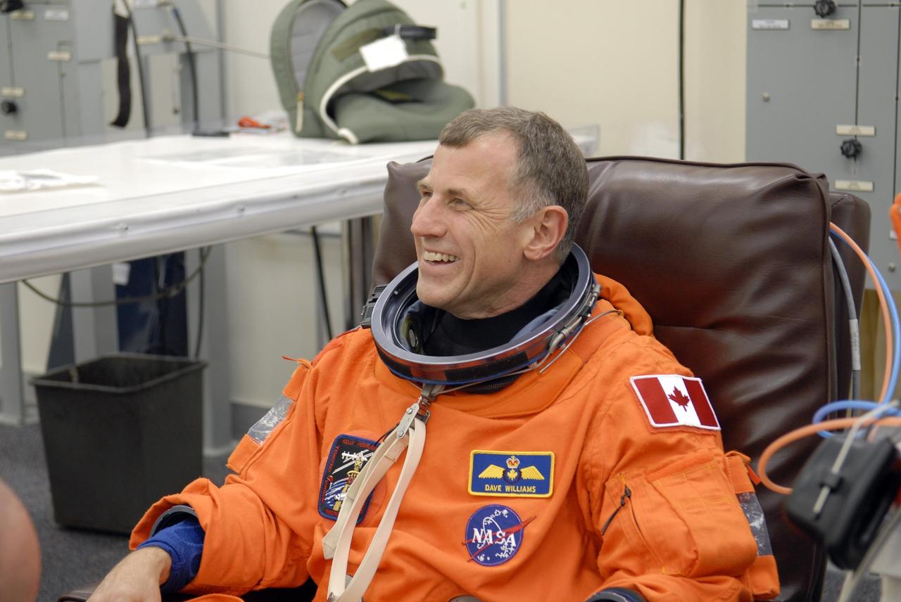 KENNEDY SPACE CENTER, FLA. -- In the Operations and Checkout Building, STS-118 Mission Specialist Dave Williams is donning his launch and entry suit before heading to Launch Pad 39A and launch of Space Shuttle Endeavour at 6:36 p.m. EDT.  Williams represents the Canadian Space Agency.  Space Shuttle Endeavour's STS-118 mission is the 22nd shuttle flight to the International Space Station. It will continue space station construction by delivering a third starboard truss segment, S5, and other payloads such as the SPACEHAB module and the external stowage platform 3.  The 11-day mission may be extended to as many as 14 depending on the test of the Station-to-Shuttle Power Transfer System that will allow the docked shuttle to draw electrical power from the station and extend its visits to the orbiting lab.  NASA/Kim Shiflett