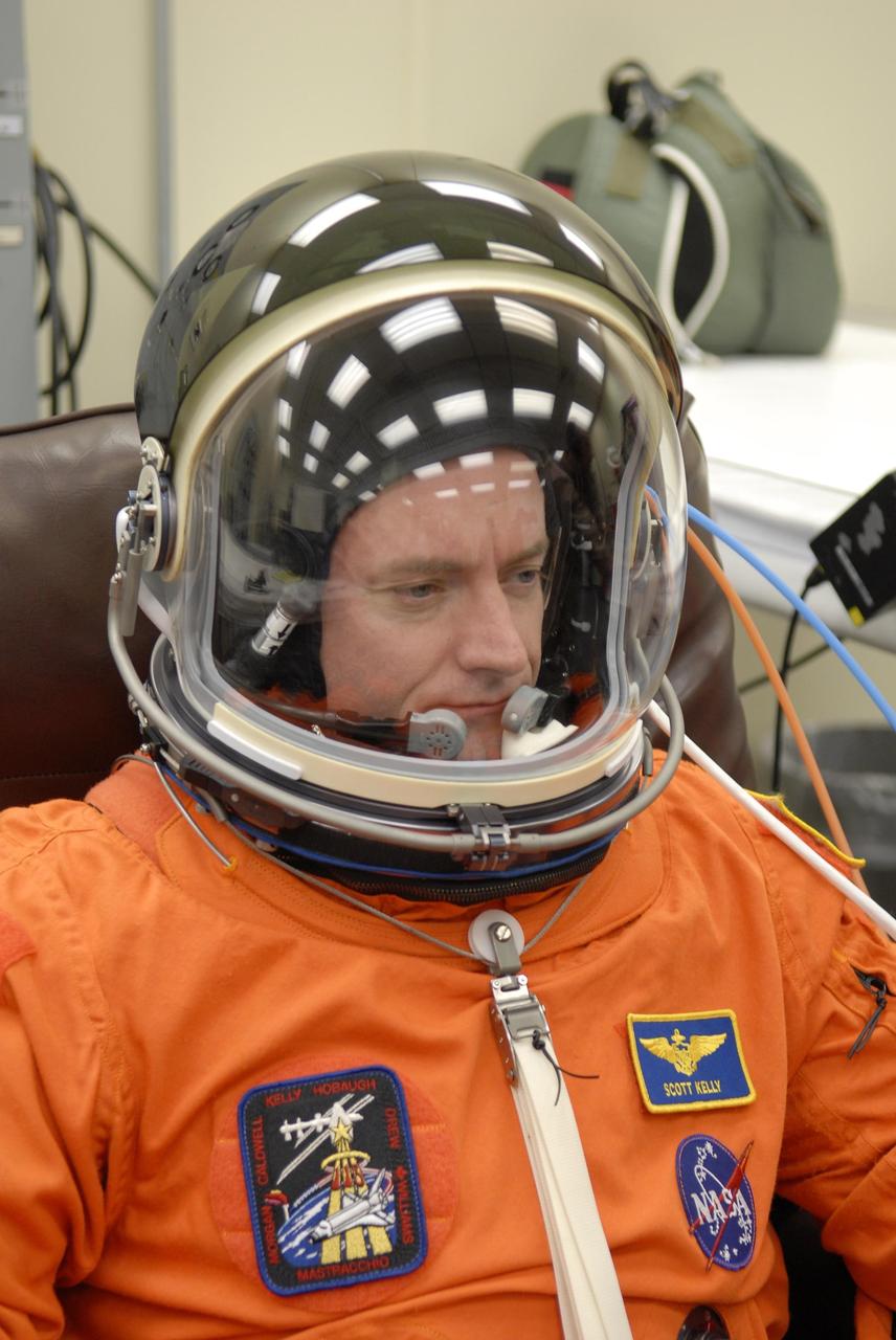 KENNEDY SPACE CENTER, FLA. --  In the Operations and Checkout Building, STS-118 Commander Scott Kelly completes suitup with his helmet.  Kelly is eager for liftoff aboard Space Shuttle Endeavour, scheduled at 6:36 p.m. EDT.  The STS-118 mission is the 22nd shuttle flight to the International Space Station. It will continue space station construction by delivering a third starboard truss segment, S5, and other payloads such as the SPACEHAB module and the external stowage platform 3.  The 11-day mission may be extended to as many as 14 depending on the test of the Station-to-Shuttle Power Transfer System that will allow the docked shuttle to draw electrical power from the station and extend its visits to the orbiting lab.  NASA/Kim Shiflett