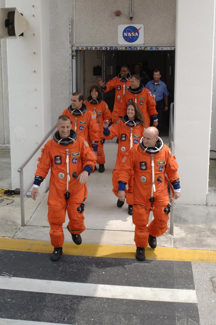 KENNEDY SPACE CENTER, FLA. --  The STS-118 crew stride out of the Operations and Checkout Building eager to get to Launch Pad 39A for launch of Space Shuttle Endeavour at 6:36 p.m. EDT.  Leading the way are (left and right) Pilot Charlie Hobaugh and Commander Scott Kelly.  Behind them, clockwise, are Mission Specialists Rick Mastracchio, teacher-turned-astronaut Barbara Morgan, Alvin Drew, Dave Williams and Tracy Caldwell.  Williams represents the Canadian Space Agency. The STS-118 mission is the 22nd shuttle flight to the International Space Station. It will continue space station construction by delivering a third starboard truss segment, S5, and other payloads such as the SPACEHAB module and the external stowage platform 3.  The 11-day mission may be extended to as many as 14 depending on the test of the Station-to-Shuttle Power Transfer System that will allow the docked shuttle to draw electrical power from the station and extend its visits to the orbiting lab.  NASA/Kim Shiflett