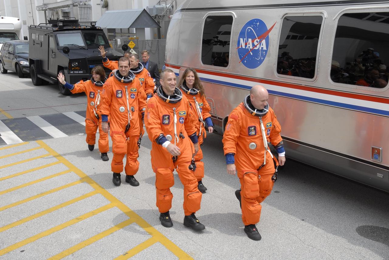 KENNEDY SPACE CENTER, FLA. --  The suited STS-118 crew moves quickly to the Astrovan after leaving the Operations and Checkout Building.  From left are Mission Specialists Barbara R. Morgan, Rick Mastracchio and Dave Williams, Pilot Charlie Hobaugh, Mission Specialist Tracy Caldwell and Commander Scott Kelly.  Behind Williams is Mission Specialist Alvin Drew. The Astrovan will take them to Launch Pad 39A for final suit preparations before climbing into Space Shuttle Endeavour for launch at 6:36 p.m. EDT. The STS-118 mission is the 22nd shuttle flight to the International Space Station. It will continue space station construction by delivering a third starboard truss segment, S5, and other payloads such as the SPACEHAB module and the external stowage platform 3.  The 11-day mission may be extended to as many as 14 depending on the test of the Station-to-Shuttle Power Transfer System that will allow the docked shuttle to draw electrical power from the station and extend its visits to the orbiting lab.  NASA/Kim Shiflett