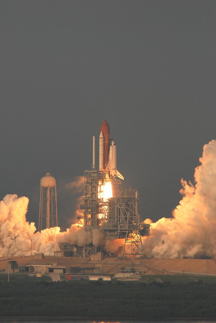KENNEDY SPACE CENTER, FLA. -- Space Shuttle Endeavour climbs above the fixed service structure on Launch Pad 39A as it begins its journey on mission STS-118.  Liftoff from Launch Pad 39A was on time at 6:36 p.m. EDT. The mission is the 22nd shuttle flight to the International Space Station. It will continue space station construction by delivering a third starboard truss segment, S5, and other payloads such as the SPACEHAB module and the external stowage platform 3.  The 11-day mission may be extended to as many as 14 depending on the test of the Station-to-Shuttle Power Transfer System that will allow the docked shuttle to draw electrical power from the station and extend its visits to the orbiting lab.  Photo credit: NASA/George Shelton