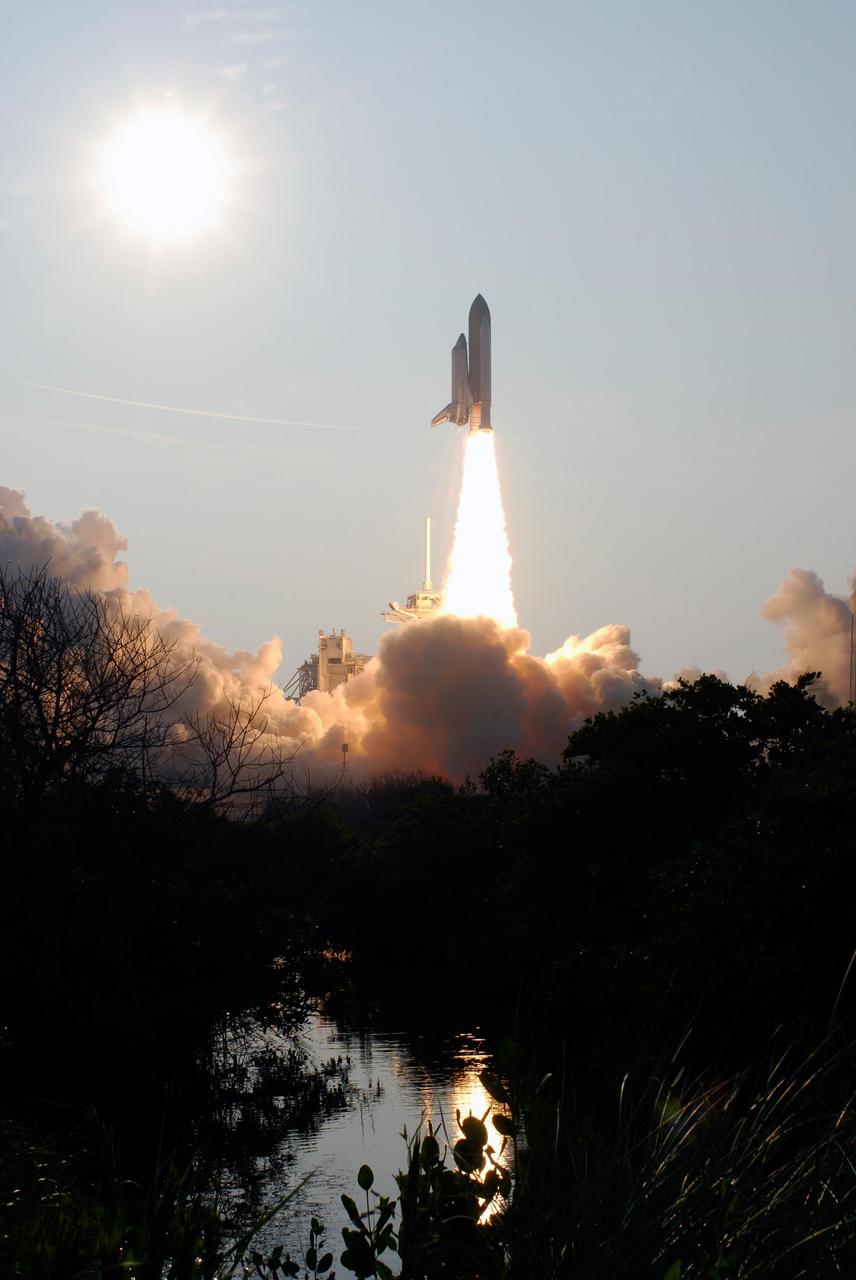 KENNEDY SPACE CENTER, FLA. --  The nearby waters catch the fiery trail from Space Shuttle Endeavour as it roars into the sky on mission STS-118.  Smoke and steam billow across Launch Pad 39A after liftoff.  The liftoff was on time at 6:36 p.m. EDT.  The mission is the 22nd shuttle flight to the International Space Station. It will continue space station construction by delivering a third starboard truss segment, S5, and other payloads such as the SPACEHAB module and the external stowage platform 3.  The 11-day mission may be extended to as many as 14 depending on the test of the Station-to-Shuttle Power Transfer System that will allow the docked shuttle to draw electrical power from the station and extend its visits to the orbiting lab.  Photo credit: NASA/Sandra Joseph, Tony Gray, Robert Murray
