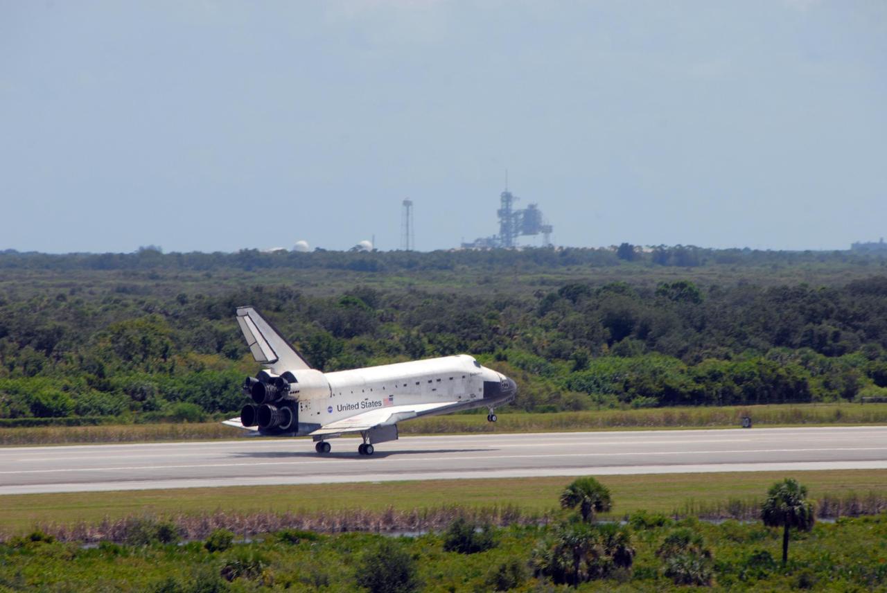 KENNEDY SPACE CENTER, FLA. -- Endeavour rolls down runway 15 at NASA's Kennedy Space Center after traveling nearly 5.3 million miles on mission STS-118.  On the horizon is Launch Pad 39B.  The Space Shuttle Endeavour crew, led by Commander Scott Kelly, completes a 13-day mission to the International Space Station.  The STS-118 mission began Aug. 8 and installed a new gyroscope, an external spare parts platform and another truss segment to the expanding station.  Endeavour's main gear touched down at 12:32:16  p.m. EDT.  Nose gear touchdown was at 12:32:29 p.m. and wheel stop was at 12:33:20 p.m.  Endeavour landed on orbit 201. STS-118 was the 119th space shuttle flight, the 22nd flight to the station, the 20th flight for Endeavour and the second of four missions planned for 2007. This was the 65th landing of an orbiter at Kennedy.  Photo credit:  NASA/Ken Thornsley