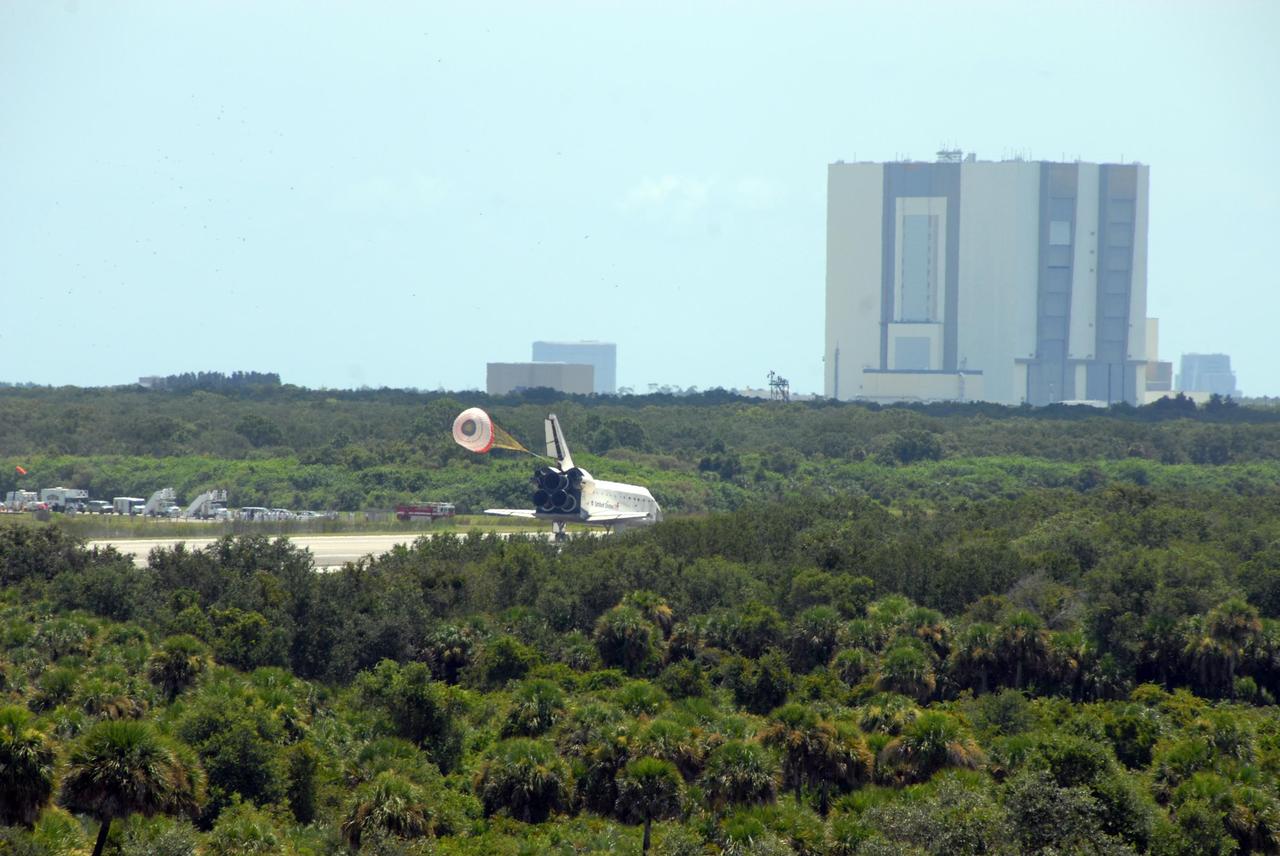 KENNEDY SPACE CENTER, FLA. -- The open drag chute helps slow Endeavour as it lands on runway 15 at NASA's Kennedy Space Center after traveling nearly 5.3 million miles on mission STS-118. In the background, at right, is the Vehicle Assembly Building. The Space Shuttle Endeavour crew, led by Commander Scott Kelly, completes a 13-day mission to the International Space Station. The STS-118 mission began Aug. 8 and installed a new gyroscope, an external spare parts platform and another truss segment to the expanding station. Endeavour's main gear touched down at 12:32:16 p.m. EDT. Nose gear touchdown was at 12:32:29 p.m. and wheel stop was at 12:33:20 p.m. Endeavour landed on orbit 201. STS-118 was the 119th space shuttle flight, the 22nd flight to the station, the 20th flight for Endeavour and the second of four missions planned for 2007. This was the 65th landing of an orbiter at Kennedy. Photo credit: NASA/Ken Thornsley
