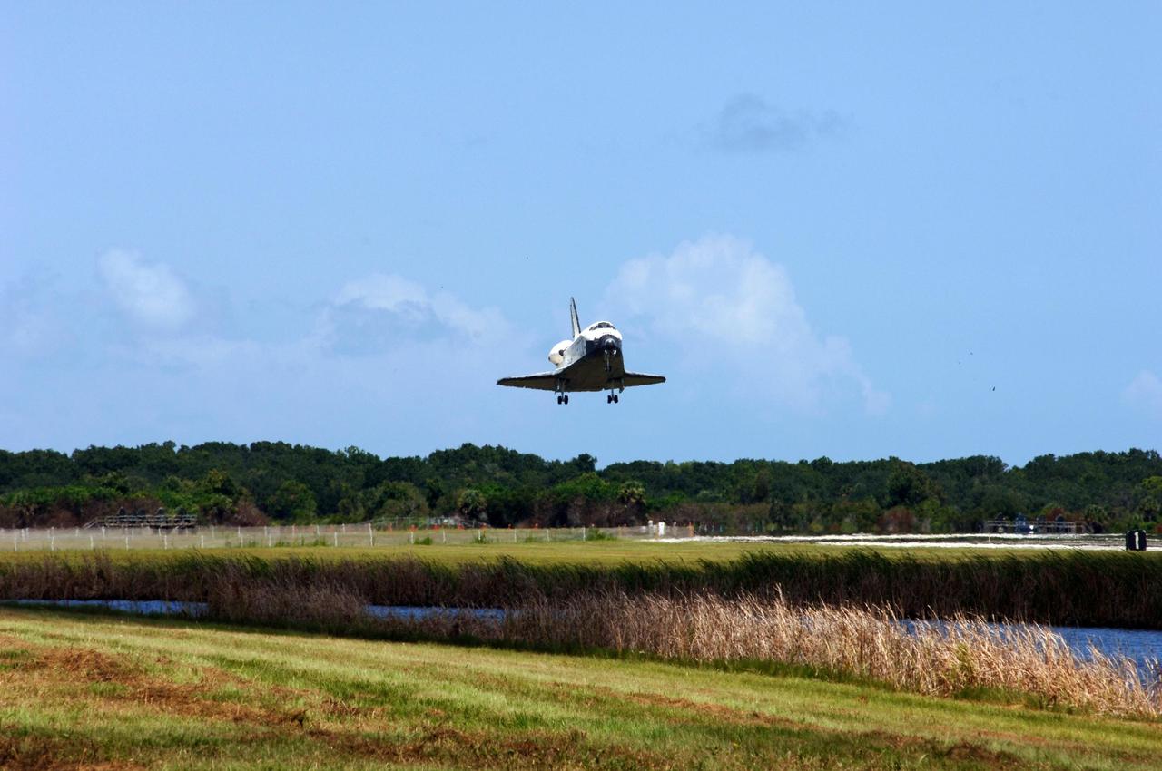 KENNEDY SPACE CENTER, FLA. -- With landing wheels down, Endeavour drops from the cloud-dotted sky to land on runway 15 at NASA's Kennedy Space Center after traveling nearly 5.3 million miles on mission STS-118. The Space Shuttle Endeavour crew, led by Commander Scott Kelly, completes a 13-day mission to the International Space Station. The STS-118 mission began Aug. 8 and installed a new gyroscope, an external spare parts platform and another truss segment to the expanding station. Endeavour's main gear touched down at 12:32:16 p.m. EDT. Nose gear touchdown was at 12:32:29 p.m. and wheel stop was at 12:33:20 p.m. Endeavour landed on orbit 201. STS-118 was the 119th space shuttle flight, the 22nd flight to the station, the 20th flight for Endeavour and the second of four missions planned for 2007. This was the 65th landing of an orbiter at Kennedy. Photo credit: NASA/Rafael Hernandez