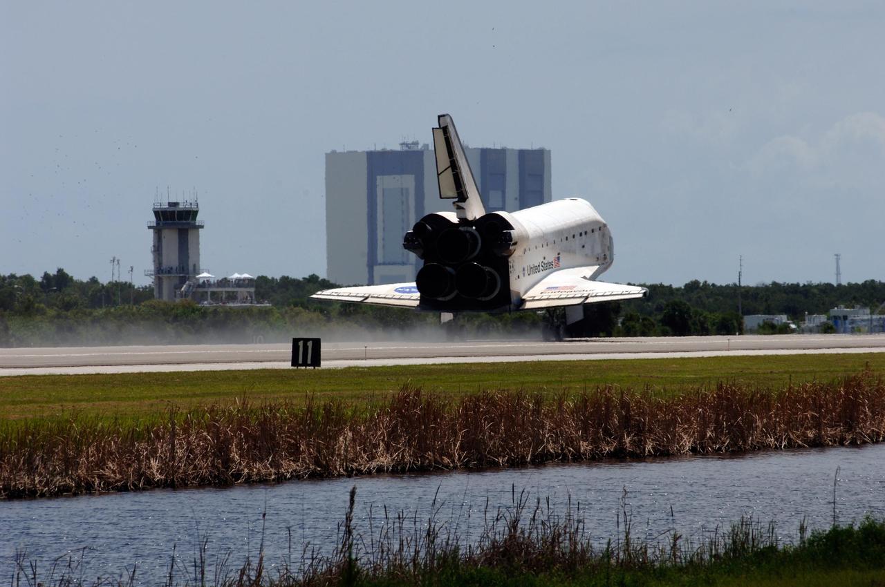 KENNEDY SPACE CENTER, FLA. --  Endeavour passes the air traffic control tower (left) next to the Shuttle Landing Facility as it touches down on runway 15 at NASA's Kennedy Space Center after traveling nearly 5.3 million miles on mission STS-118.  Behind Endeavour is the Vehicle Assembly Building.  The Space Shuttle Endeavour crew, led by Commander Scott Kelly, completes a 13-day mission to the International Space Station.  The STS-118 mission began Aug. 8 and installed a new gyroscope, an external spare parts platform and another truss segment to the expanding station.  Endeavour's main gear touched down at 12:32:16  p.m. EDT.  Nose gear touchdown was at 12:32:29 p.m. and wheel stop was at 12:33:20 p.m.  Endeavour landed on orbit 201. STS-118 was the 119th space shuttle flight, the 22nd flight to the station, the 20th flight for Endeavour and the second of four missions planned for 2007. This was the 65th landing of an orbiter at Kennedy.  Photo credit:  NASA/Rafael Hernandez