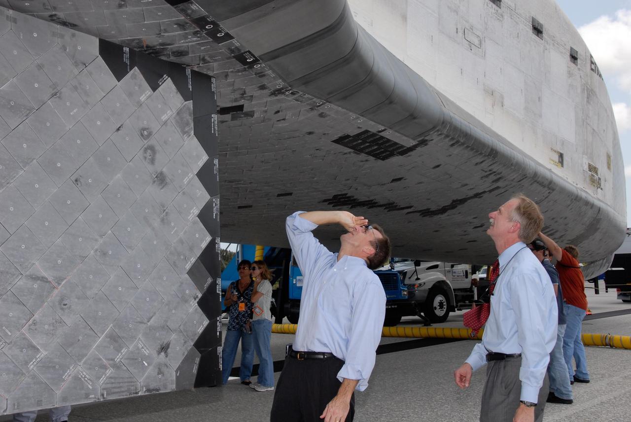 KENNEDY SPACE CENTER, FLA. -- On the Shuttle Landing Facility at NASA's Kennedy Space Center, Mission Launch Integration Director Leroy Cain (left) and Associate Administrator for NASA Space Operations William Gerstenmaier get a closer look at the wing leading edge under Endeavour.  The orbiter is just returned from mission STS-118, which began Aug. 8. The crew installed a new gyroscope, an external spare parts platform and another truss segment to the expanding station.  Endeavour's main gear touched down at 12:32:16  p.m. EDT.  Nose gear touchdown was at 12:32:29 p.m. and wheel stop was at 12:33:20 p.m.  Endeavour landed on orbit 201. STS-118 was the 119th space shuttle flight, the 22nd flight to the station, the 20th flight for Endeavour and the second of four missions planned for 2007. This was the 65th landing of an orbiter at Kennedy.  Photo credit:  NASA/Kim Shiflett