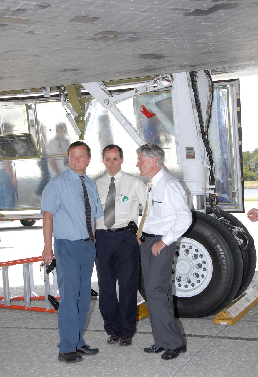 KENNEDY SPACE CENTER, FLA. -- On the Shuttle Landing Facility at NASA's Kennedy Space Center, Shuttle Launch Director Mike Leinbach, Director General for Operations and Assets Benoit Marcotte  and Canadian Space Agency President Laurier Boisvert stand underneath Endeavour, which has just returned from mission STS-118. On the mission, the crew installed a new gyroscope, an external spare parts platform and another truss segment to the expanding station.   On landing, Endeavour's main gear touched down at 12:32:16  p.m. EDT.  Nose gear touchdown was at 12:32:29 p.m. and wheel stop was at 12:33:20 p.m.  Endeavour traveled nearly 5.3 million miles, landing on orbit 201.  This was the 65th landing of an orbiter at Kennedy.  STS-118 was the 119th space shuttle flight, the 22nd flight to the station, the 20th flight for Endeavour and the second of four missions planned for 2007.  Photo credit:  NASA/Kim Shiflett