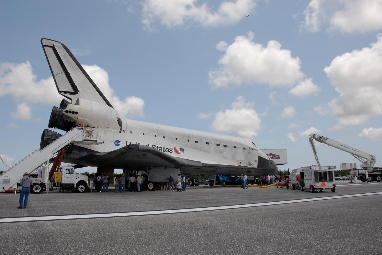 KENNEDY SPACE CENTER, FLA. --  On the Shuttle Landing Facility at NASA's Kennedy Space Center, officials gather to look for damaged tiles on the underside of Endeavour, just returned from mission STS-118.  On the mission, the crew installed a new gyroscope, an external spare parts platform and another truss segment to the expanding station.  Endeavour's main gear touched down at 12:32:16  p.m. EDT.  Nose gear touchdown was at 12:32:29 p.m. and wheel stop was at 12:33:20 p.m.  Endeavour landed on orbit 201. STS-118 was the 119th space shuttle flight, the 22nd flight to the station, the 20th flight for Endeavour and the second of four missions planned for 2007. This was the 65th landing of an orbiter at Kennedy.  Photo credit:  NASA/Kim Shiflett