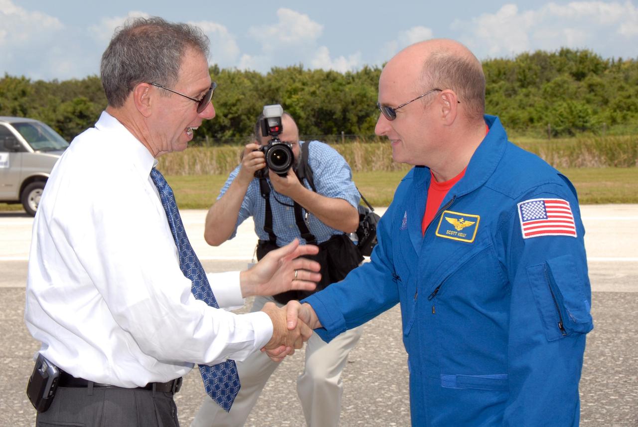 KENNEDY SPACE CENTER, FLA. --    A photographer captures the moment as NASA Administrator Mike Griffin (left) welcomes STS-118 Commander Scott Kelly back to Earth after completing mission STS-118. On the mission, the crew installed a new gyroscope, an external spare parts platform and another truss segment to the expanding station.  Endeavour's main gear touched down at 12:32:16  p.m. EDT.  Nose gear touchdown was at 12:32:29 p.m. and wheel stop was at 12:33:20 p.m.  Endeavour landed on orbit 201. STS-118 was the 119th space shuttle flight, the 22nd flight to the station, the 20th flight for Endeavour and the second of four missions planned for 2007. This was the 65th landing of an orbiter at Kennedy.  Photo credit:  NASA/Kim Shiflett