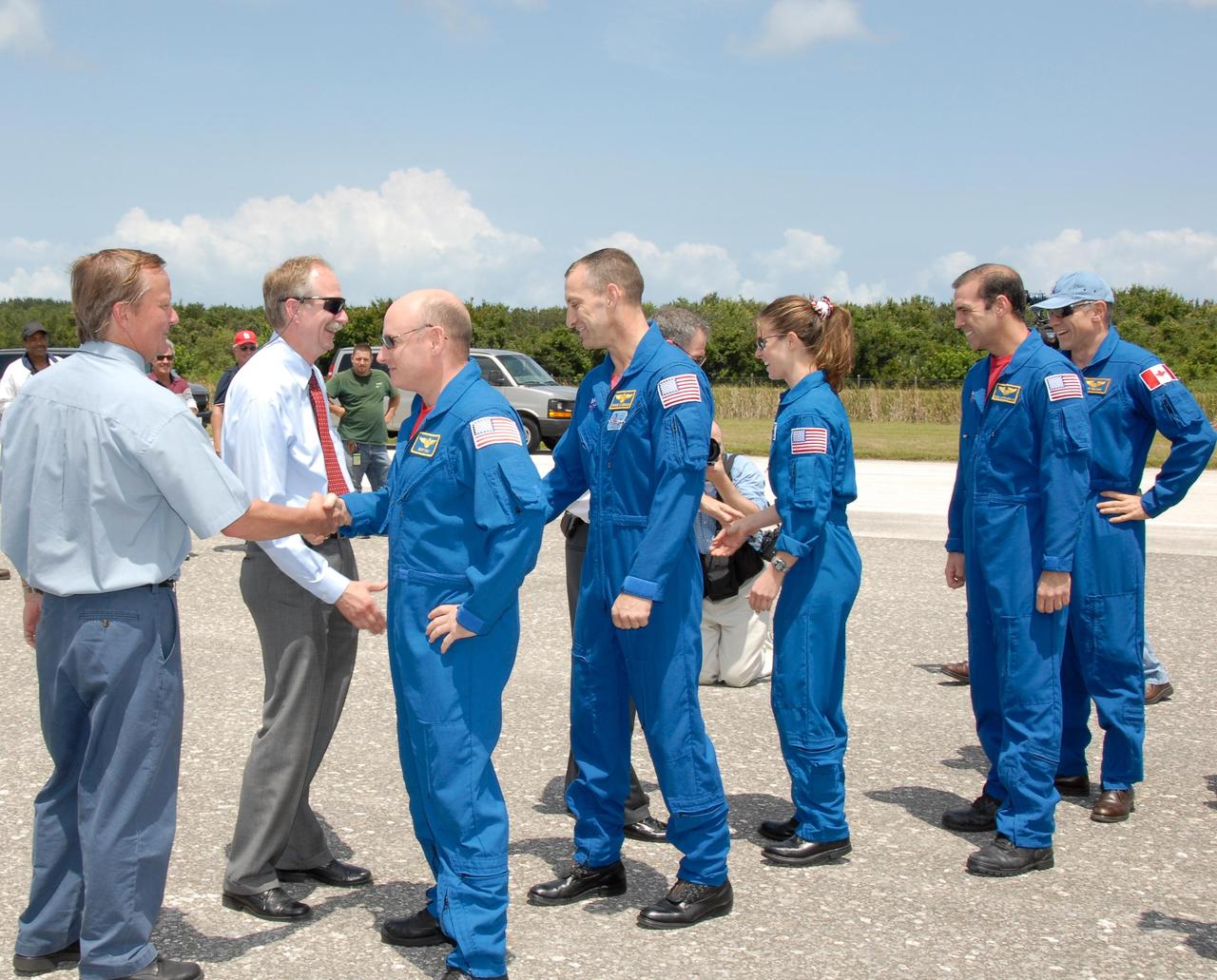 KENNEDY SPACE CENTER, FLA. --   The STS-118 crew is welcomed back to Earth by NASA officials after completing mission STS-118.  From left are Shuttle Launch Director Mike Leinbach, Associate Administrator for Space Operations William Gerstenmaier, Commander Scott Kelly, Pilot Charlie Hobaugh, NASA Administrator Mike Griffin, and Mission Specialists Tracy Caldwell, Rick Mastracchio and Canadian astronaut Dave Williams.  On the mission, the crew installed a new gyroscope, an external spare parts platform and another truss segment to the expanding station.  Endeavour's main gear touched down at 12:32:16  p.m. EDT.  Nose gear touchdown was at 12:32:29 p.m. and wheel stop was at 12:33:20 p.m.  Endeavour landed on orbit 201. STS-118 was the 119th space shuttle flight, the 22nd flight to the station, the 20th flight for Endeavour and the second of four missions planned for 2007. This was the 65th landing of an orbiter at Kennedy.  Photo credit:  NASA/Kim Shiflett