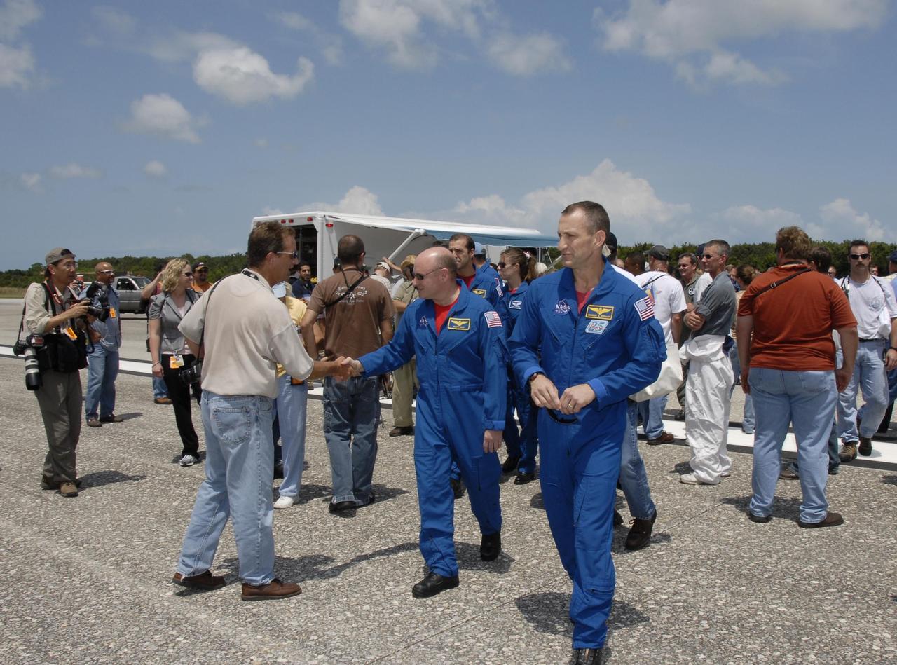 KENNEDY SPACE CENTER, FLA. --   After being welcomed back to Earth from their successful mission, the STS-118 crew heads for Endeavour and a close look at the underside of the orbiter.  In the front are Commander Scott Kelly (left) and Pilot Charlie Hobaugh.  Seen behind them are Mission Specialists Rick Mastracchio and Tracy Caldwell. On the mission, the crew installed a new gyroscope, an external spare parts platform and another truss segment to the expanding station.  Endeavour's main gear touched down at 12:32:16  p.m. EDT.  Nose gear touchdown was at 12:32:29 p.m. and wheel stop was at 12:33:20 p.m.  Endeavour landed on orbit 201. STS-118 was the 119th space shuttle flight, the 22nd flight to the station, the 20th flight for Endeavour and the second of four missions planned for 2007. This was the 65th landing of an orbiter at Kennedy.  Photo credit:  NASA/Kim Shiflett