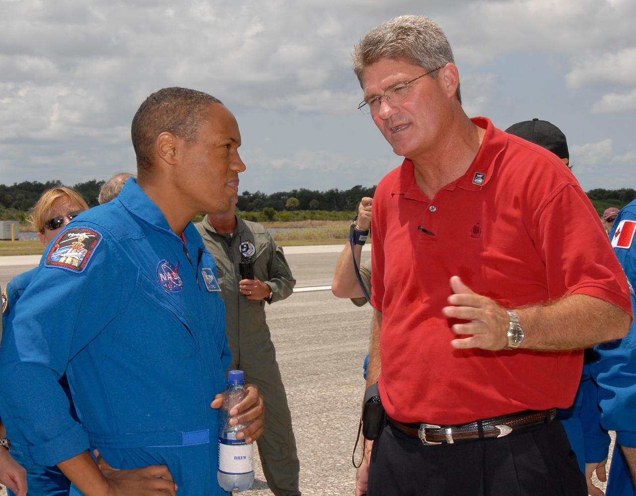 KENNEDY SPACE CENTER, FLA. --   KSC Director Bill Parsons (right) is one of the NASA officials present to welcome back the STS-118 crew from its mission to the International Space Station.  Parsons is talking to Mission Specialist Alvin Drew. On the mission, the crew installed a new gyroscope, an external spare parts platform and another truss segment to the expanding station.  Endeavour's main gear touched down at 12:32:16  p.m. EDT.  Nose gear touchdown was at 12:32:29 p.m. and wheel stop was at 12:33:20 p.m.  Endeavour landed on orbit 201. STS-118 was the 119th space shuttle flight, the 22nd flight to the station, the 20th flight for Endeavour and the second of four missions planned for 2007. This was the 65th landing of an orbiter at Kennedy.  Photo credit:  NASA/Kim Shiflett