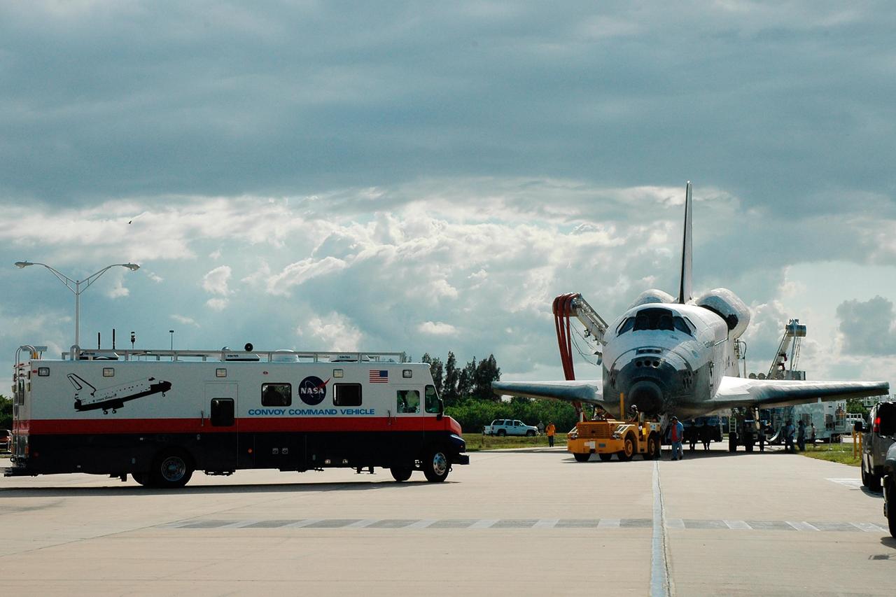 KENNEDY SPACE CENTER, FLA. --    The orbiter Endeavour is towed toward the Orbiter Processing Facility, known as the OPF.  At left is the Convoy Command Vehicle.  The mobile command center is the prime vehicle to control critical communications between the orbiter, the crew and the Launch Control Center after a shuttle landing to monitor the health of the shuttle orbiter systems and to direct convoy operations at the Shuttle Landing Facility.  Endeavour returned to Earth Aug. 21 from mission STS-118, landing at Kennedy at 12:32 p.m. EDT. In the OPF bay 2, Endeavour will incur thermal protection system inspections and numerous other post-flight inspections before processing starts for its next voyage into space.  Endeavour will next fly on mission STS-123 targeted for Feb. 14, 2008.  Photo credit: NASA/Jack Pfaller