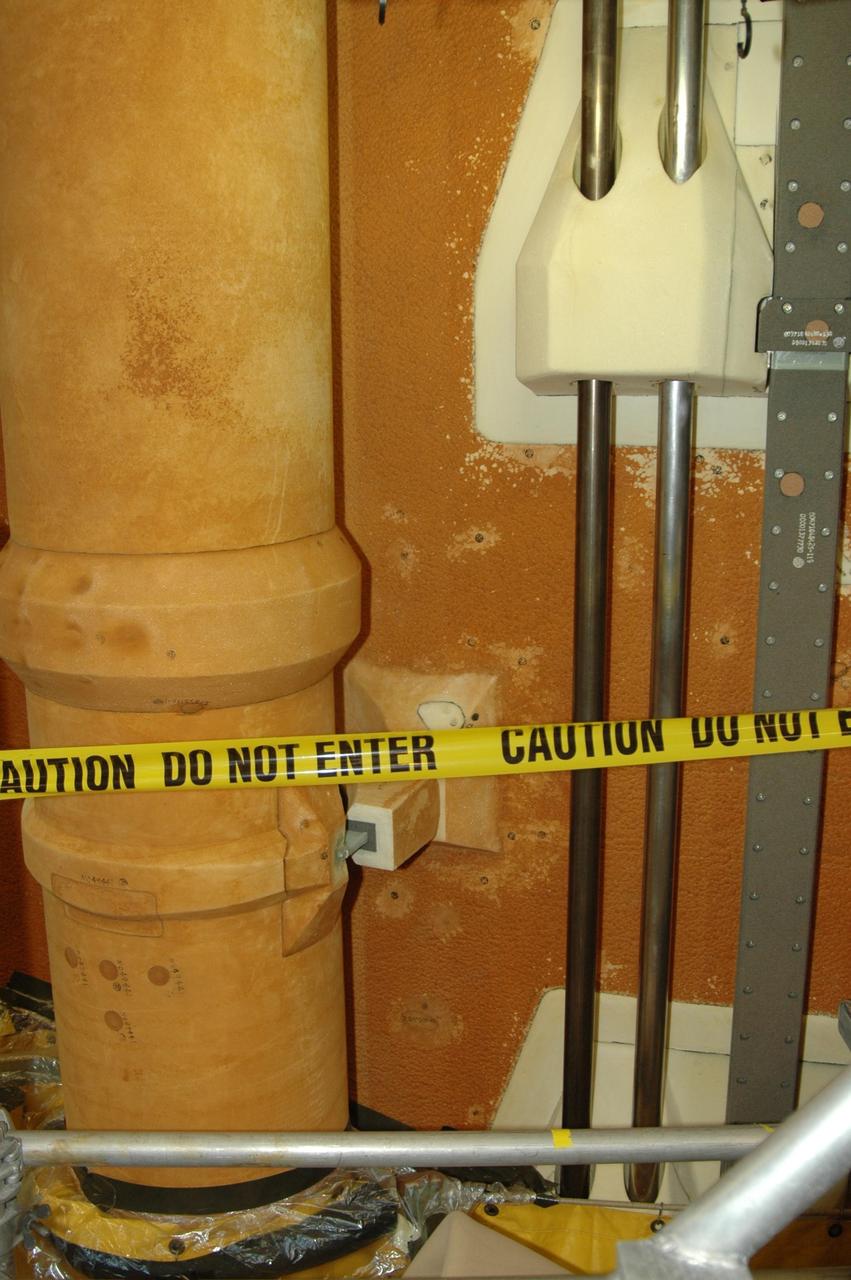 KENNEDY SPACE CENTER, FLA. -- The BX265 foam insulation and super lightweight ablator, or SLA, cork insulation has been removed from the L02 feed line bracket that is attached to the external tank.  Also visible is the adjacent LO2 feed line. The BX265 foam insulation will later be reapplied without the SLA.  The tank is scheduled to fly on Space Shuttle Discovery in October 2007 on mission STS-120.  Discovery's crew will add the module Harmony that will serve as a port for installing additional international laboratories. Harmony will be the first expansion of the living and working space on the complex since the Russian Pirs airlock was installed in 2001. The mission also will move the first set of solar arrays installed on the station to a permanent location on the complex and redeploy them.  Photo credit: NASA/Jim Grossmann