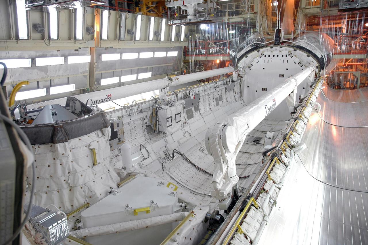 KENNEDY SPACE CENTER, FLA. -- In the Orbiter Processing Facility, preparations are under way to close the payload bay doors of Discovery for the rollover of the orbiter to the Vehicle Assembly Building. Seen along the edges of the bay are the Canadian-built shuttle robotic arm and orbiter boom sensor system. The primary payload, the U.S. Node 2, which is named Harmony, will be installed in the payload bay at the pad prior to Discovery's liftoff on mission STS-120. The mission will be the 23rd flight for the assembly of the International Space Station. Space Shuttle Discovery is targeted for launch on Oct. 23. Photo credit: NASA/Jim Grossmann