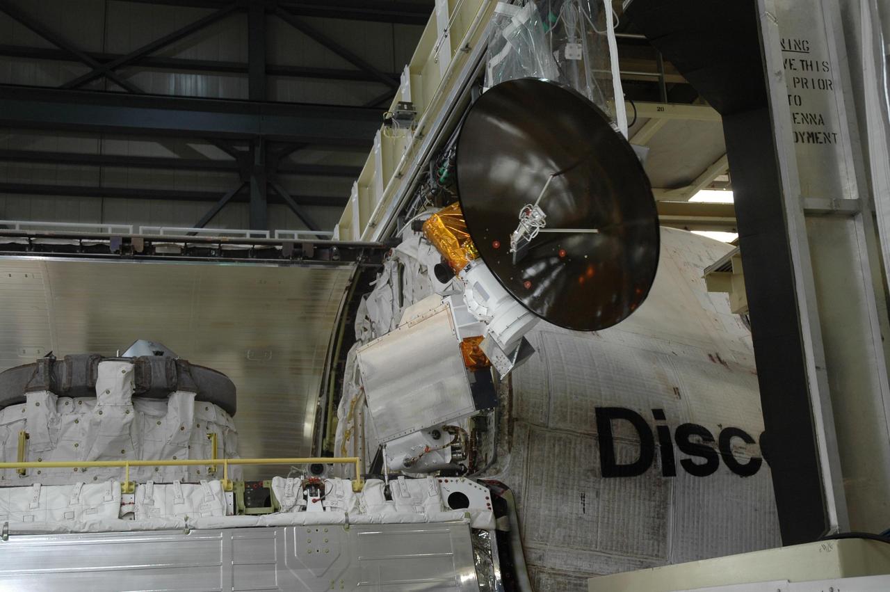 KENNEDY SPACE CENTER, FLA. -- In the Orbiter Processing Facility, the Ku-band communications antenna is stowed in the payload bay of Discovery before the bay's doors are closed. The stowage is in preparation for the rollover of the orbiter to the Vehicle Assembly Building. The primary payload, the U.S. Node 2, which is named Harmony, will be installed in the payload bay at the pad prior to Discovery's liftoff on mission STS-120. The mission will be the 23rd flight for the assembly of the International Space Station. Space Shuttle Discovery is targeted for launch on Oct. 23. Photo credit: NASA/Jim Grossmann