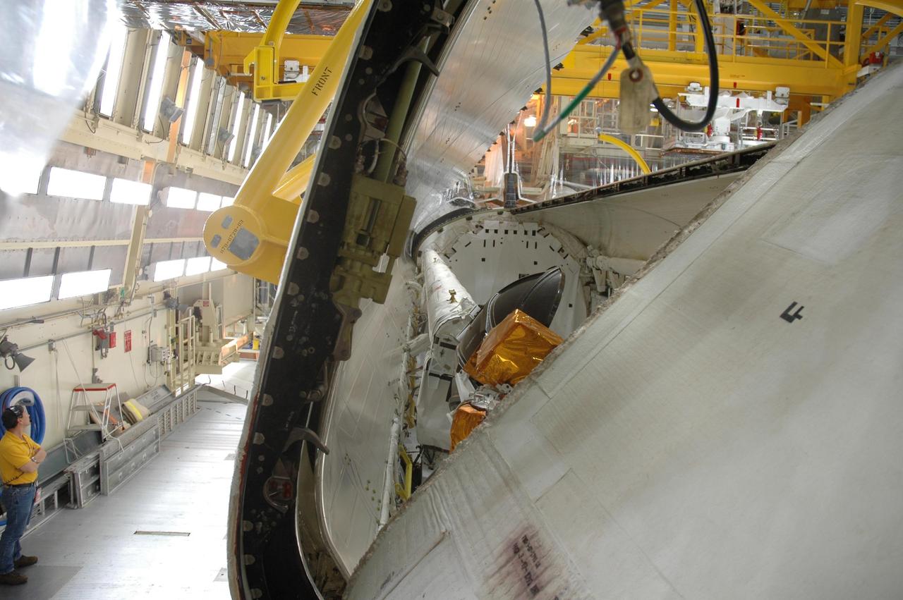 KENNEDY SPACE CENTER, FLA. -- In the Orbiter Processing Facility, the right payload bay door of Discovery is being closed in preparation for the rollover of the orbiter to the Vehicle Assembly Building. The primary payload, the U.S. Node 2, which is named Harmony, will be installed in the payload bay at the pad prior to Discovery's liftoff on mission STS-120. The mission will be the 23rd flight for the assembly of the International Space Station. Space Shuttle Discovery is targeted for launch on Oct. 23. Photo credit: NASA/Jim Grossmann
