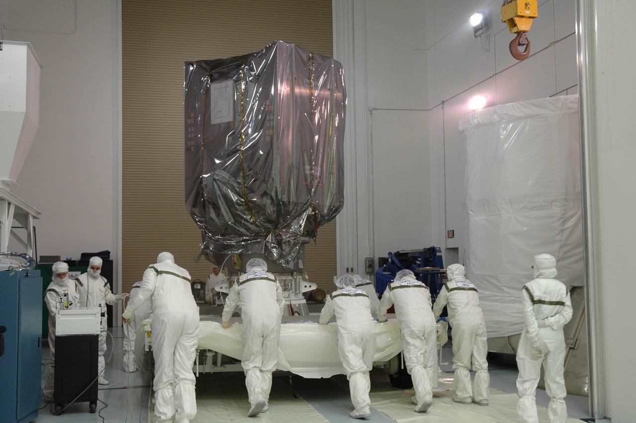 KENNEDY SPACE CENTER, FLA. -- At Astrotech Space Operations in Titusville, Fla., workers move the platform with the Dawn spacecraft.  They are preparing to install the transportation canister around Dawn for transfer to Launch Pad 17-B at Cape Canaveral Air Force Station (CCAFS).  During its nearly decade-long mission, the Dawn mission will study the asteroid Vesta and dwarf planet Ceres, celestial bodies believed to have accreted early in the history of the solar system. To carry out its scientific mission, the Dawn spacecraft will carry a visible camera, a visible and infrared mapping spectrometer, and a gamma ray and neutron spectrometer, whose data will be used in combination to characterize these bodies.  In addition to the three instruments, radiometric and optical navigation data will provide data relating to the gravity field and thus bulk properties and internal structure of the two bodies. Data returned from the Dawn spacecraft could provide opportunities for significant breakthroughs in our knowledge of how the solar system formed. Launch via a Delta II rocket is scheduled in a window from 7:25 to 7:54 a.m. Sept. 26 from CCAFS.  Photo credit: NASA/Jim Grossmann