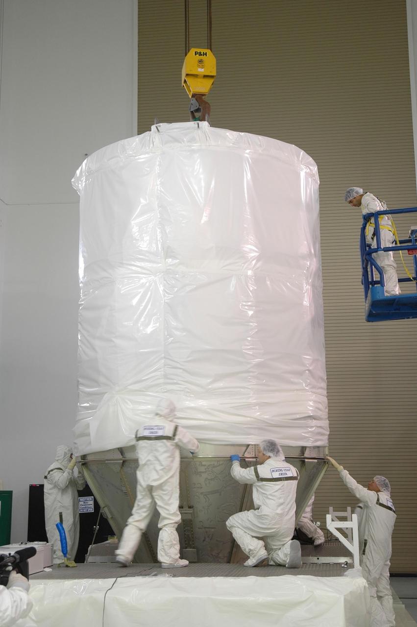 KENNEDY SPACE CENTER, FLA. -- At Astrotech Space Operations in Titusville, Fla., workers ensure the upper transportation canister is securely attached to the lower segments.  The canister will protect the spacecraft and booster during transfer to Launch Pad 17-B at Cape Canaveral Air Force Station (CCAFS).  During its nearly decade-long mission, the Dawn mission will study the asteroid Vesta and dwarf planet Ceres, celestial bodies believed to have accreted early in the history of the solar system. To carry out its scientific mission, the Dawn spacecraft will carry a visible camera, a visible and infrared mapping spectrometer, and a gamma ray and neutron spectrometer, whose data will be used in combination to characterize these bodies.  In addition to the three instruments, radiometric and optical navigation data will provide data relating to the gravity field and thus bulk properties and internal structure of the two bodies. Data returned from the Dawn spacecraft could provide opportunities for significant breakthroughs in our knowledge of how the solar system formed. Launch via a Delta II rocket is scheduled in a window from 7:25 to 7:54 a.m. Sept. 26 from CCAFS.  Photo credit: NASA/Jim Grossmann