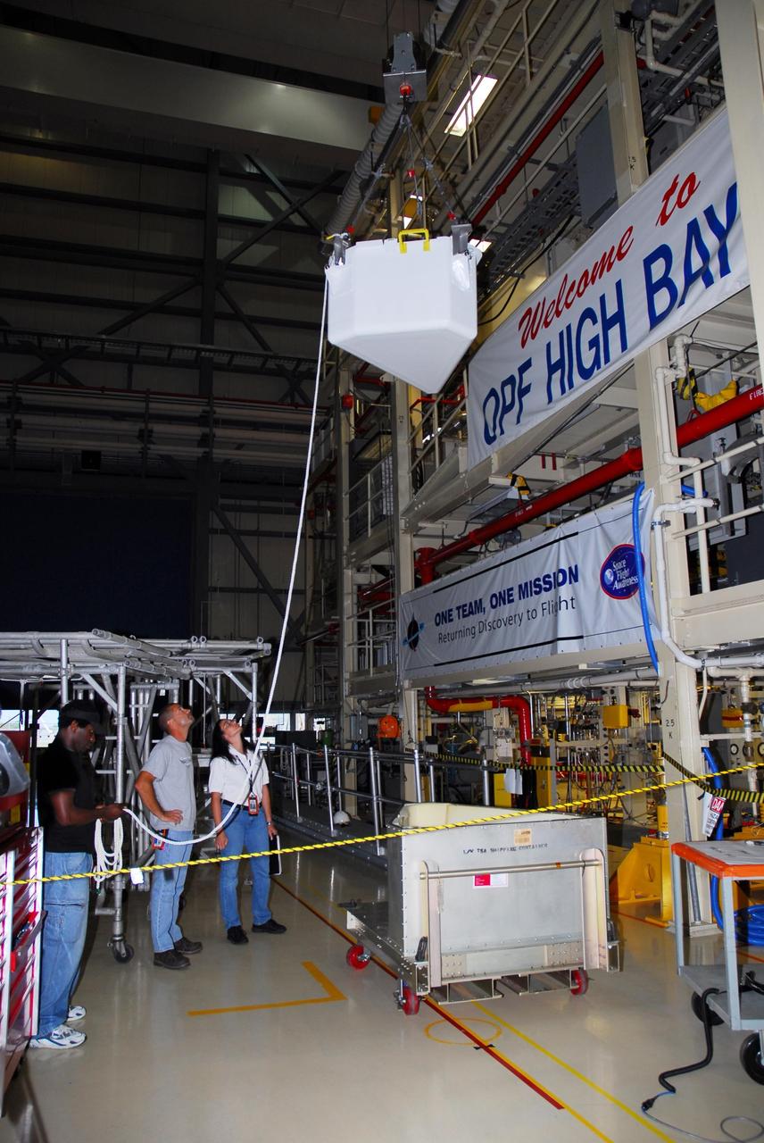 KENNEDY SPACE CENTER, FLA. --  In bay 3 of the Orbiter Processing Facility, a tool storage assembly unit is being moved for storage in Discovery's payload bay. The tools may be used on a spacewalk, yet to be determined, during mission STS-120.    In an unusual operation, the payload bay doors had to be reopened after closure to accommodate the storage.  Space shuttle Discovery is targeted to launch Oct. 23 to the International Space Station.  It will carry the U.S. Node 2, a connecting module, named Harmony, for assembly on the space station.  Photo credit: NASA/Amanda Diller