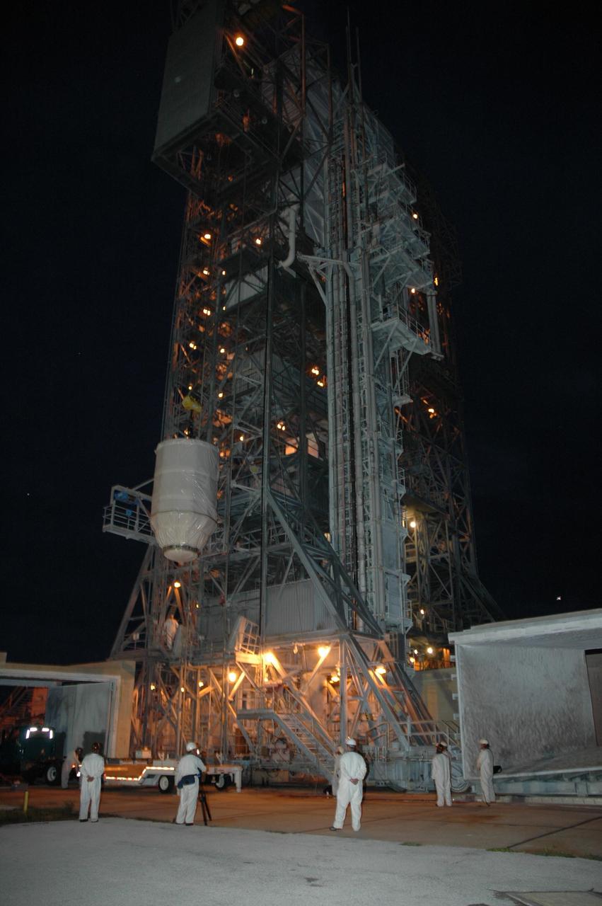 KENNEDY SPACE CENTER, FLA. --  On Launch Pad 17-B at Cape Canaveral Air Force Station, the Dawn spacecraft is lifted alongside the mobile service tower.  At the top, Dawn will be prepared for mating with the awaiting Delta II rocket.  Dawn is scheduled for launch in a window from 7:25 to 7:54 a.m. Sept. 26 from CCAFS.  During its nearly decade-long mission, the Dawn mission will study the asteroid Vesta and dwarf planet Ceres, celestial bodies believed to have accreted early in the history of the solar system. To carry out its scientific mission, the Dawn spacecraft will carry a visible camera, a visible and infrared mapping spectrometer, and a gamma ray and neutron spectrometer, whose data will be used in combination to characterize these bodies.  In addition to the three instruments, radiometric and optical navigation data will provide data relating to the gravity field and thus bulk properties and internal structure of the two bodies. Data returned from the Dawn spacecraft could provide opportunities for significant breakthroughs in our knowledge of how the solar system formed. Photo credit: NASA/Jack Pfaller