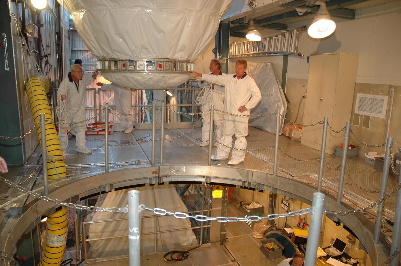 KENNEDY SPACE CENTER, FLA. -- On Launch Pad 17-B at Cape Canaveral Air Force Station, the Dawn spacecraft is moved toward the opening above the Delta II rocket in the mobile service tower. Dawn will be mated with the Delta in preparation for launch. Dawn is scheduled for launch in a window from 7:25 to 7:54 a.m. Sept. 26 from CCAFS. During its nearly decade-long mission, the Dawn mission will study the asteroid Vesta and dwarf planet Ceres, celestial bodies believed to have accreted early in the history of the solar system. To carry out its scientific mission, the Dawn spacecraft will carry a visible camera, a visible and infrared mapping spectrometer, and a gamma ray and neutron spectrometer, whose data will be used in combination to characterize these bodies. In addition to the three instruments, radiometric and optical navigation data will provide data relating to the gravity field and thus bulk properties and internal structure of the two bodies. Data returned from the Dawn spacecraft could provide opportunities for significant breakthroughs in our knowledge of how the solar system formed. Photo credit: NASA/Jack Pfaller