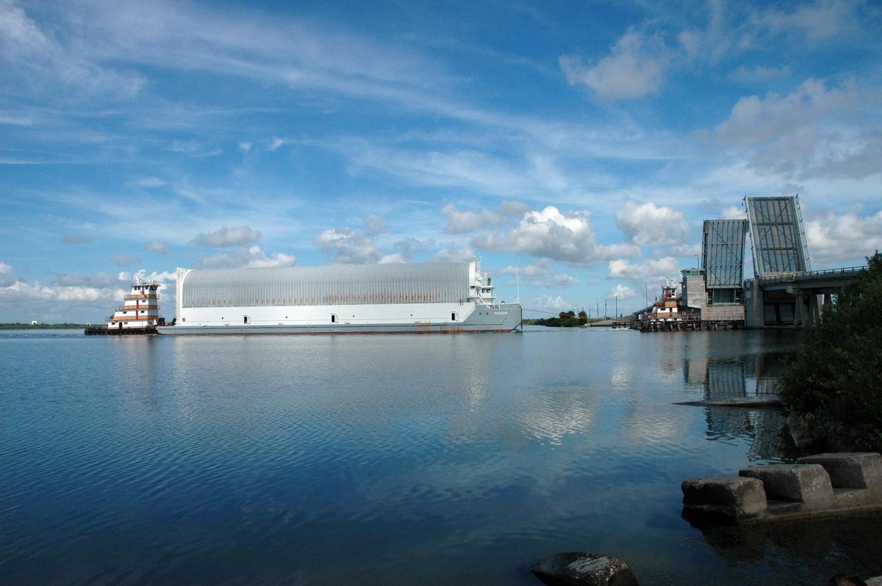 KENNEDY SPACE CENTER, FLA. -- Tugboats tow the Pegasus barge through the bridge at the haulover canal on the Banana River. The barge is carrying external tank No. 125. After it is offloaded, the tank will be moved to the Vehicle Assembly Building. The external tank will be used on space shuttle Atlantis for mission STS-122 targeted for launch on Dec. 6. Photo credit: NASA/Troy Cryder