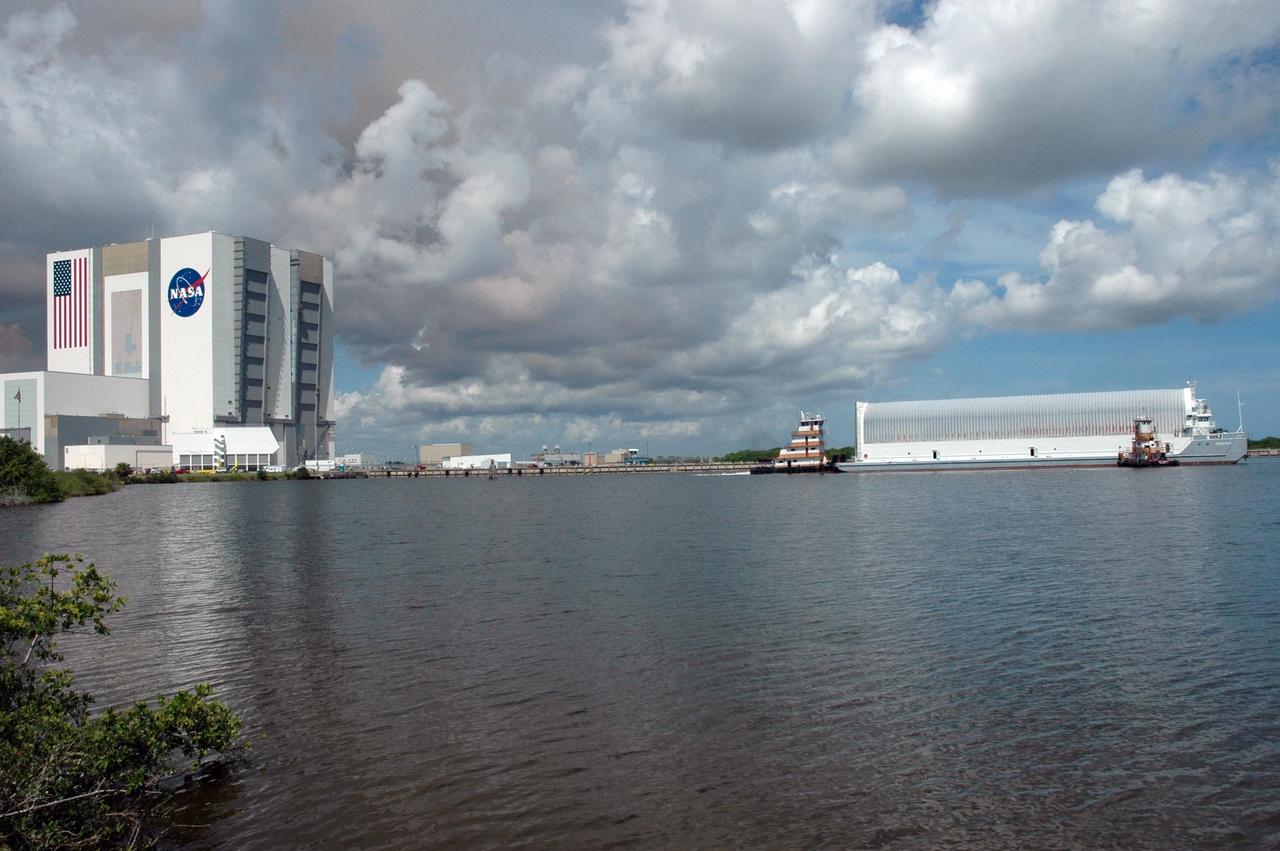 KENNEDY SPACE CENTER, FLA. --    Tugboats tow the Pegasus barge toward the dock in the turn basin of the Launch Complex 39 Area.  At left is the Vehicle Assembly Building.  The barge is carrying external tank No. 125.  After it is offloaded, the tank will be moved to the Vehicle Assembly Building. The external tank will be used on space shuttle Atlantis for mission STS-122 targeted for launch on Dec. 6.  Photo credit: NASA/Troy Cryder