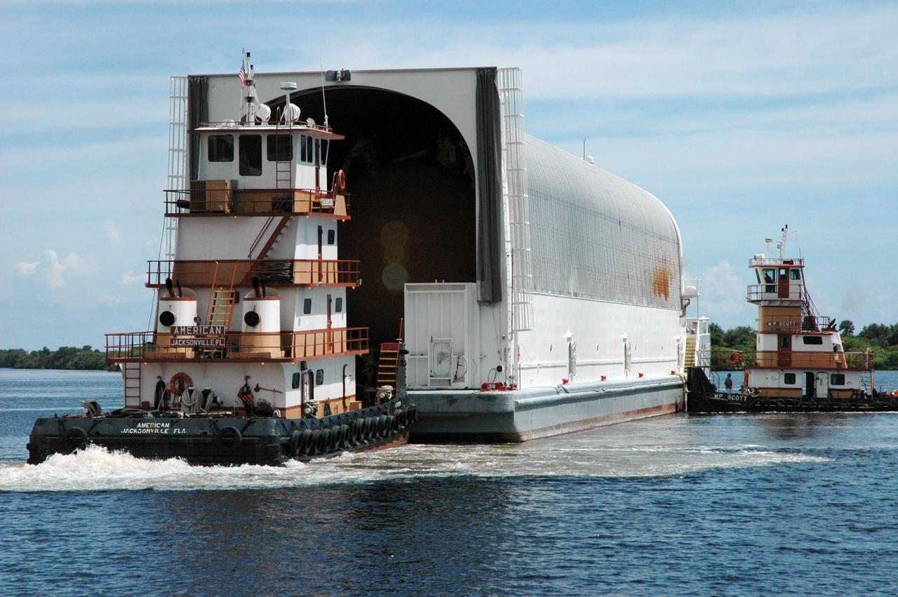 KENNEDY SPACE CENTER, FLA. -- Tugboats maneuver the Pegasus barge toward the dock in the turn basin of the Launch Complex 39 Area. The barge is carrying external tank No. 125. After it is offloaded, the tank will be moved to the Vehicle Assembly Building. The external tank will be used on space shuttle Atlantis for mission STS-122 targeted for launch on Dec. 6. Photo credit: NASA/Troy Cryder