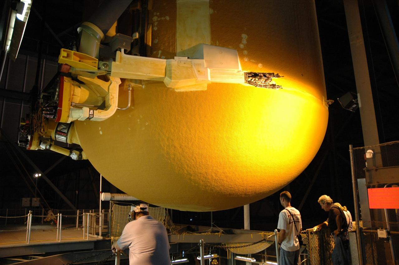 KENNEDY SPACE CENTER, FLA. --   In the Vehicle Assembly Building, workers keep an eye on the movement of external tank No. 125 as it is lowered into a checkout cell in high bay 4 for processing.  The tank will be part of the space shuttle stack for mission STS-122 targeted to launch Dec. 6.  Photo credit: NASA/Troy Cryder