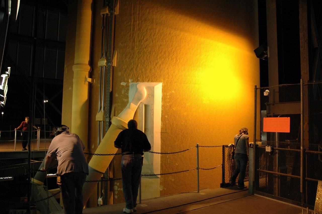 KENNEDY SPACE CENTER, FLA. --   In the Vehicle Assembly Building, workers keep an eye on the movement of external tank No. 125 as it is lowered into a checkout cell in high bay 4 for processing. The tank will be part of the space shuttle stack for mission STS-122 targeted to launch Dec. 6.  Photo credit: NASA/Troy Cryder