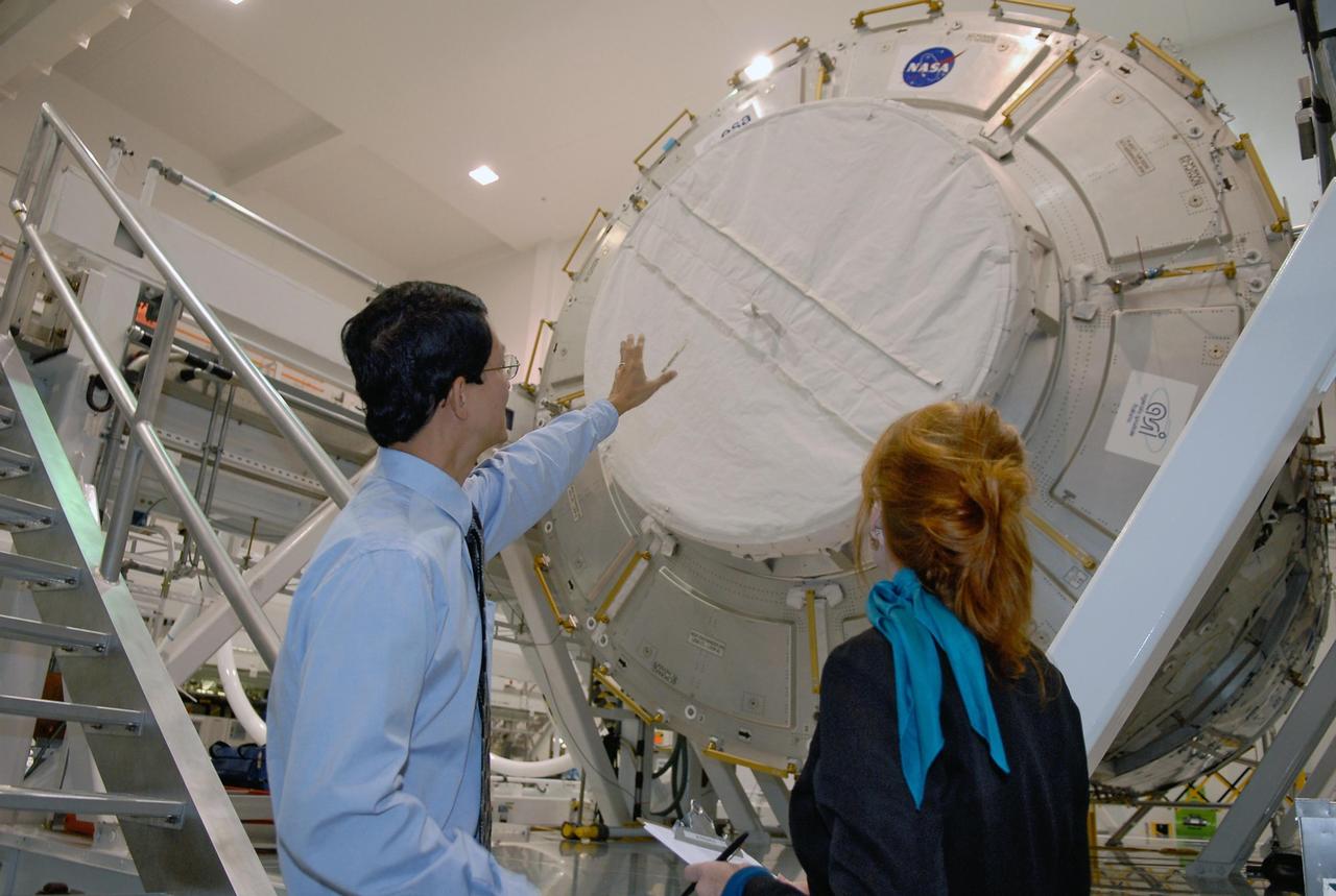 KENNEDY SPACE CENTER, FLA. -- A media event at NASA's Kennedy Space Center highlighted the next piece to be added to the International Space Station, the Italian-built Node-2 module, known as Harmony. At left, Glenn C. Chin, mission manager for International Space Station and Spacecraft Processing, talks to a reporter about processing of the Harmony module in front of them. Harmony will launch aboard space shuttle Discovery on mission STS-120, targeted for launch Oct. 23. The module is scheduled to be transferred at the end of the month to Launch Pad 39A, in preparation for its journey to the station. Harmony is approximately 21 feet long and 14 feet in diameter. It will act as an internal connecting port and passageway to additional international science labs and cargo spacecraft. The pressurized module will increase the living and working space inside the station and serve as a work platform outside for the station's robotic arm. Photo credit: NASA/Kim Shiflett