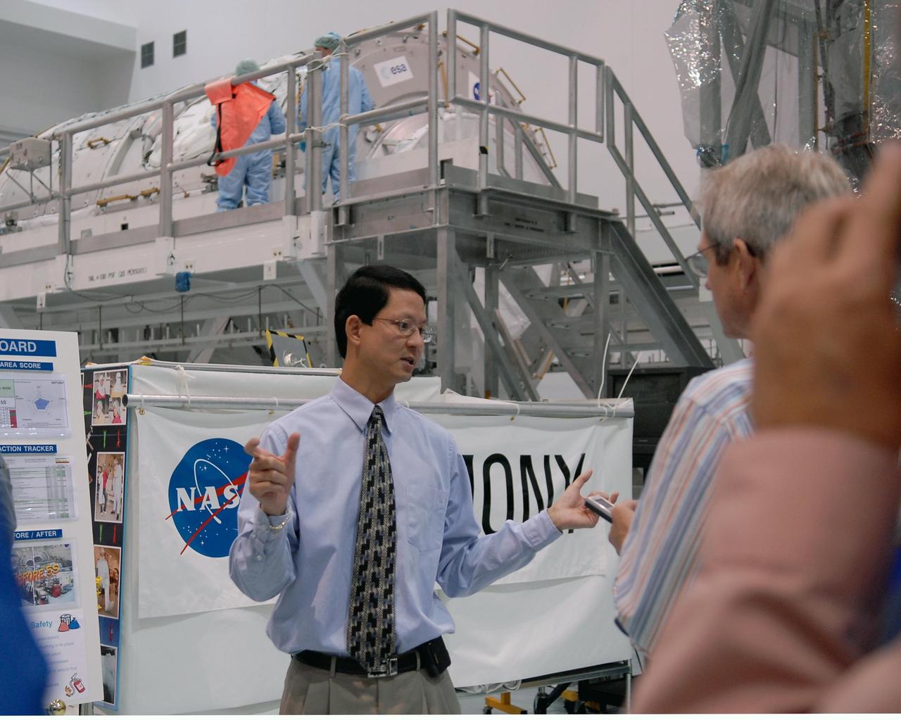 KENNEDY SPACE CENTER, FLA. -- A media event at NASA's Kennedy Space Center highlighted the next piece to be added to the International Space Station, the Italian-built Node-2 module, known as Harmony. At center, Glenn C. Chin, mission manager for International Space Station and Spacecraft Processing, talks to reporters about processing of the Harmony module. Harmony will launch aboard space shuttle Discovery on mission STS-120, targeted for launch Oct. 23. The module is scheduled to be transferred at the end of the month to Launch Pad 39A, in preparation for its journey to the station. Harmony is approximately 21 feet long and 14 feet in diameter. It will act as an internal connecting port and passageway to additional international science labs and cargo spacecraft. The pressurized module will increase the living and working space inside the station and serve as a work platform outside for the station's robotic arm. Photo credit: NASA/Kim Shiflett