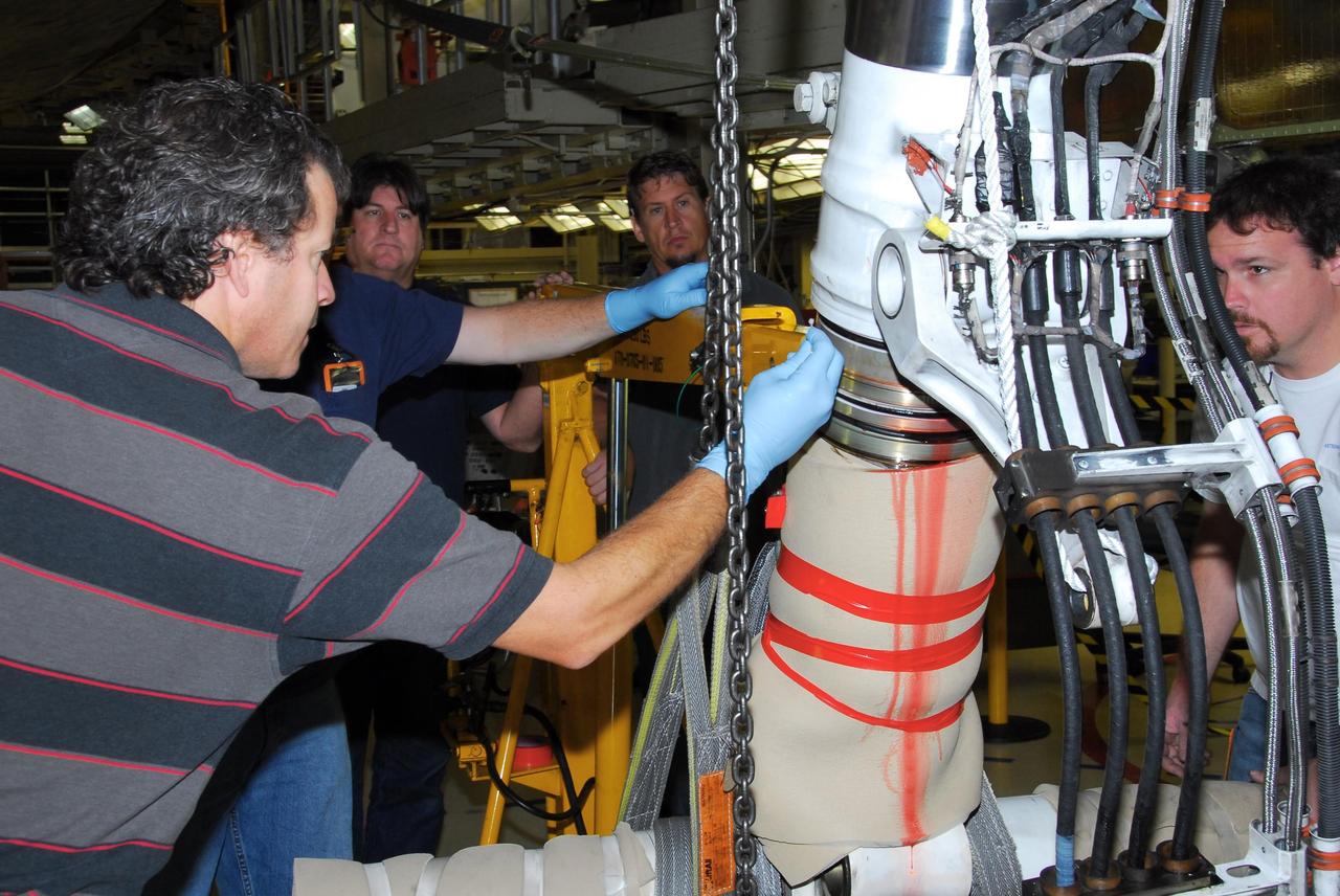 KENNEDY SPACE CENTER, FLA. -- In Orbiter Processing Facility bay 3,  United Space Alliance and B.F. Goodrich technicians begin work on the starboard landing gear assembly of space shuttle Discovery.  They will replace a leaking dynamic seal in Discovery's right main-gear strut. The struts act as shock absorbers during the shuttle's landing.  Engineers determined the observed leak of hydraulic fluid in the main landing gear strut exceeded specification and could not be reduced to an acceptable rate. Removing the strut and replacing seals require disconnecting and replacing the brakes and tires, disconnecting and reconnecting instruments and other requirements to allow access to the strut.  Discovery had been scheduled to roll over Sept. 19 from its processing hangar to the Vehicle Assembly Building. A new rollover date will be set after technicians determine how long replacing the seal will take.  Photo credit: NASA/George Shelton