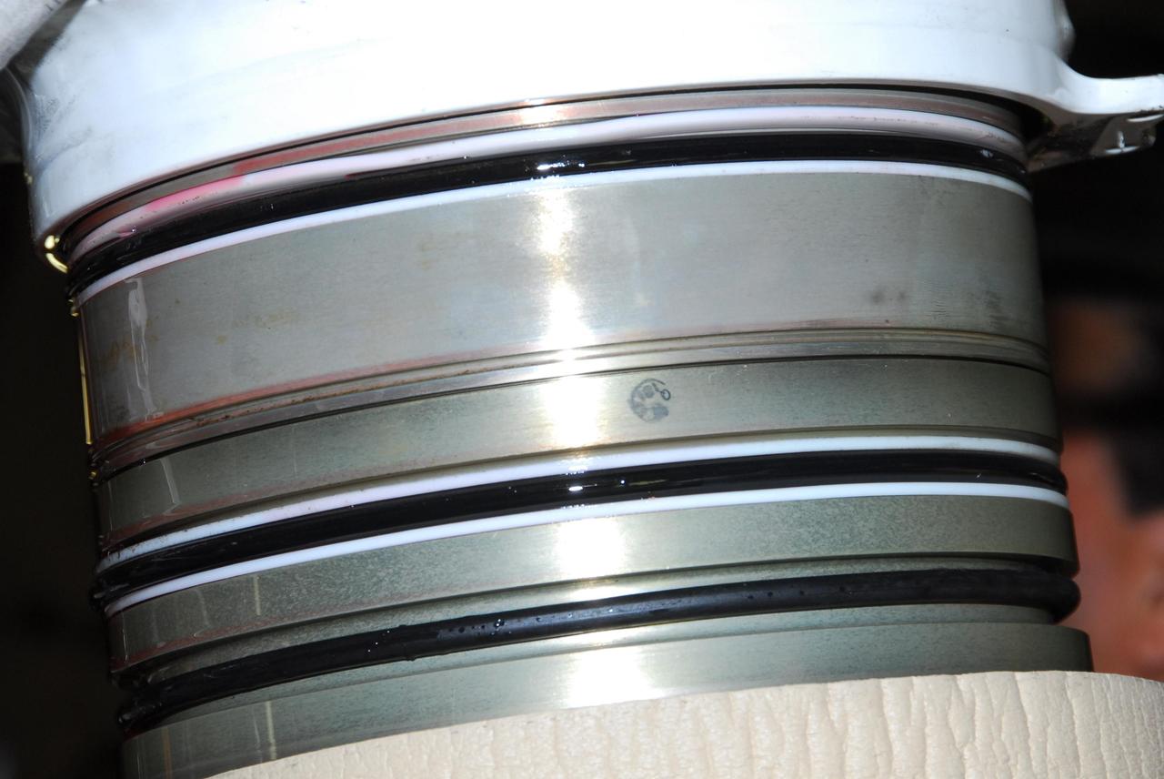 KENNEDY SPACE CENTER, FLA. -- This photo shows the leaking hydraulic seal in space shuttle Discovery's right main-gear strut. United Space Alliance and B.F. Goodrich technicians are working to replace the seal.  The struts act as shock absorbers during the shuttle's landing.  Engineers determined the observed leak of hydraulic fluid in the main landing gear strut exceeded specification and could not be reduced to an acceptable rate. Removing the strut and replacing seals require disconnecting and replacing the brakes and tires, disconnecting and reconnecting instruments and other requirements to allow access to the strut.  Discovery had been scheduled to roll over Sept. 19 from its processing hangar to the Vehicle Assembly Building. A new rollover date will be set after technicians determine how long replacing the seal will take.  Photo credit: NASA/George Shelton